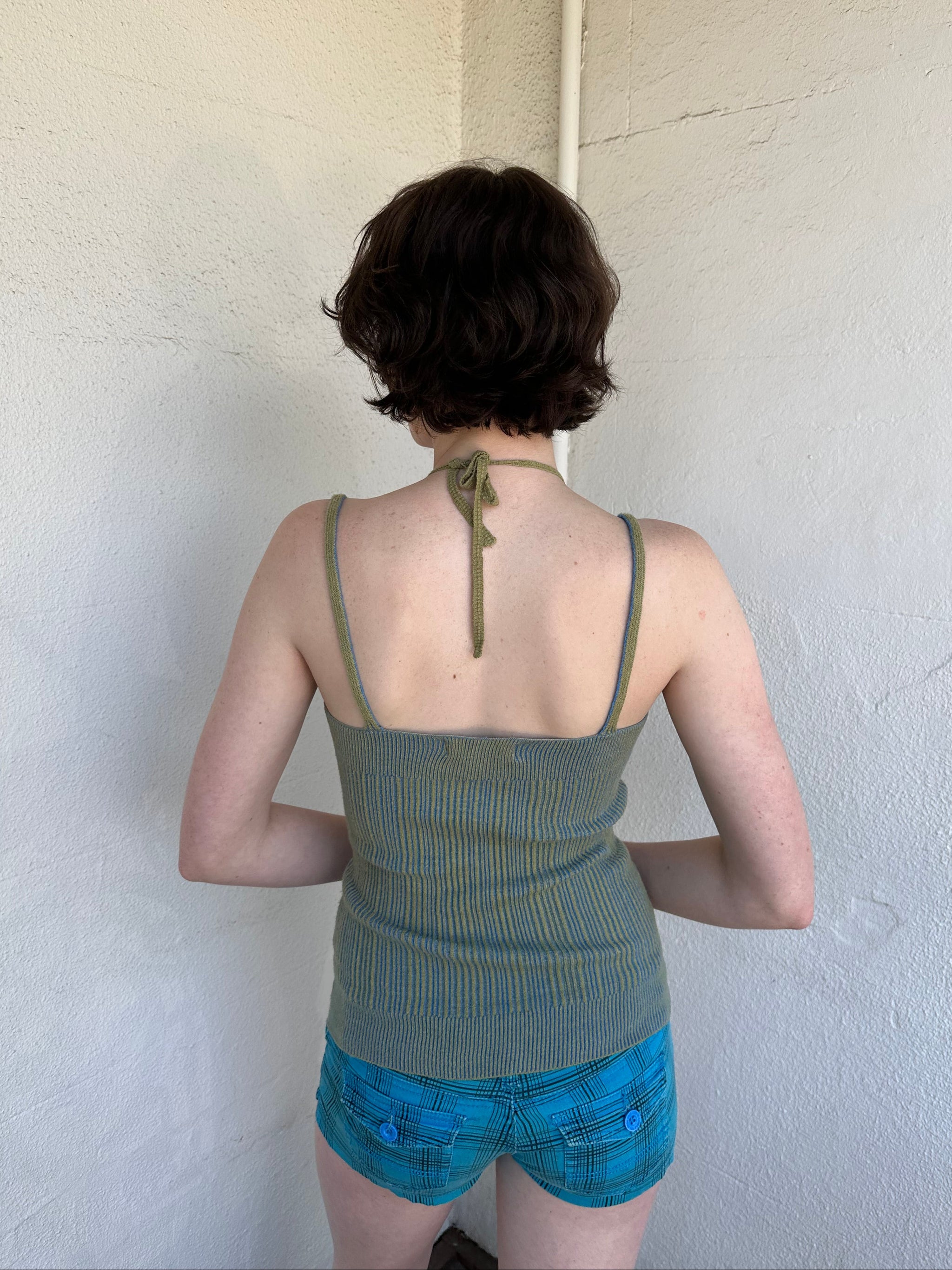 Woman Dressed in Y2K Green and blue layered knitted top featuring a two-toned blue and green ribbed knit.