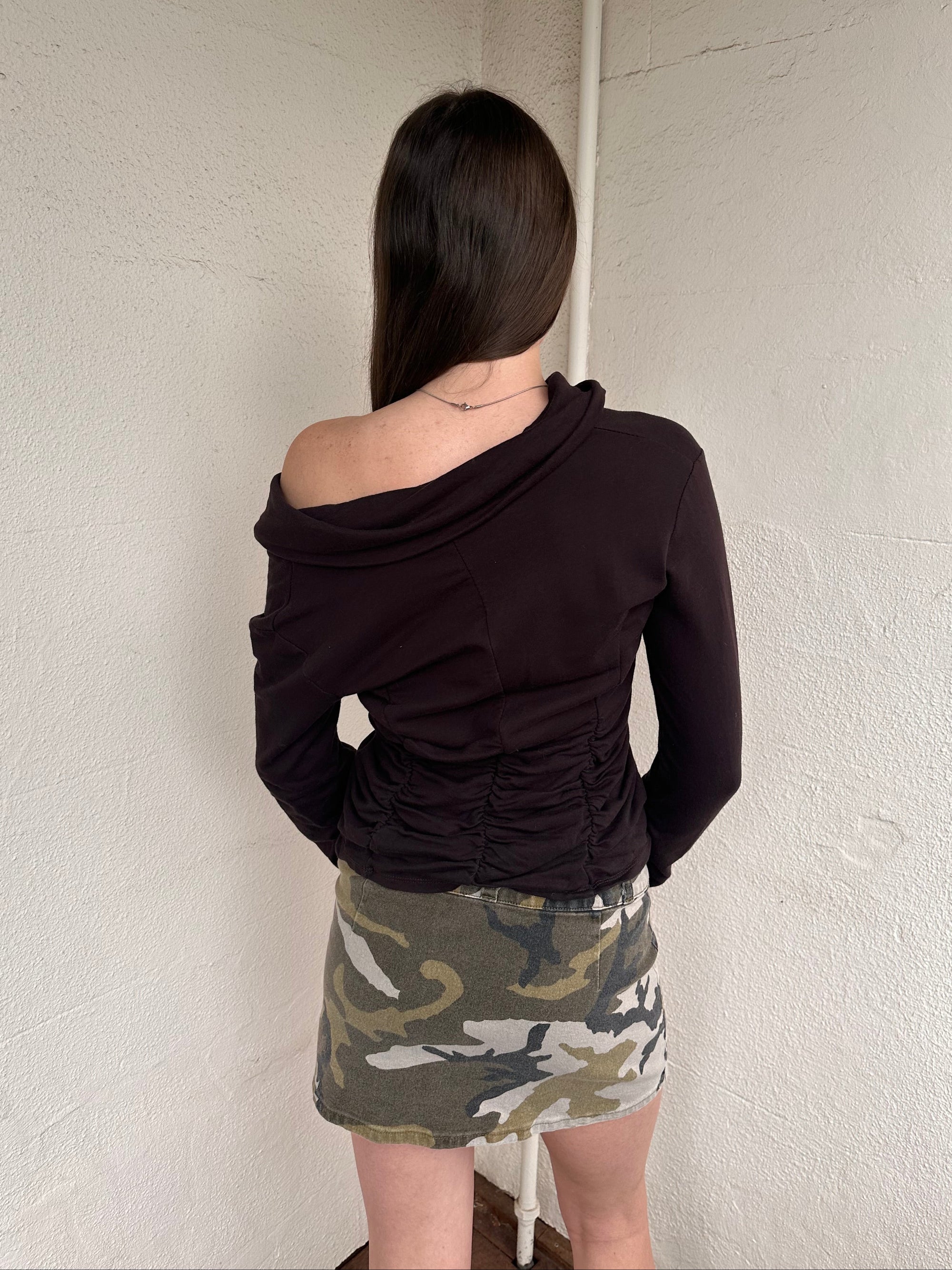 Women wearing a 00s Y2K Green camo denim mini skirt with a built-in belt. Crafted from sturdy denim with cargo-style detailing for added texture