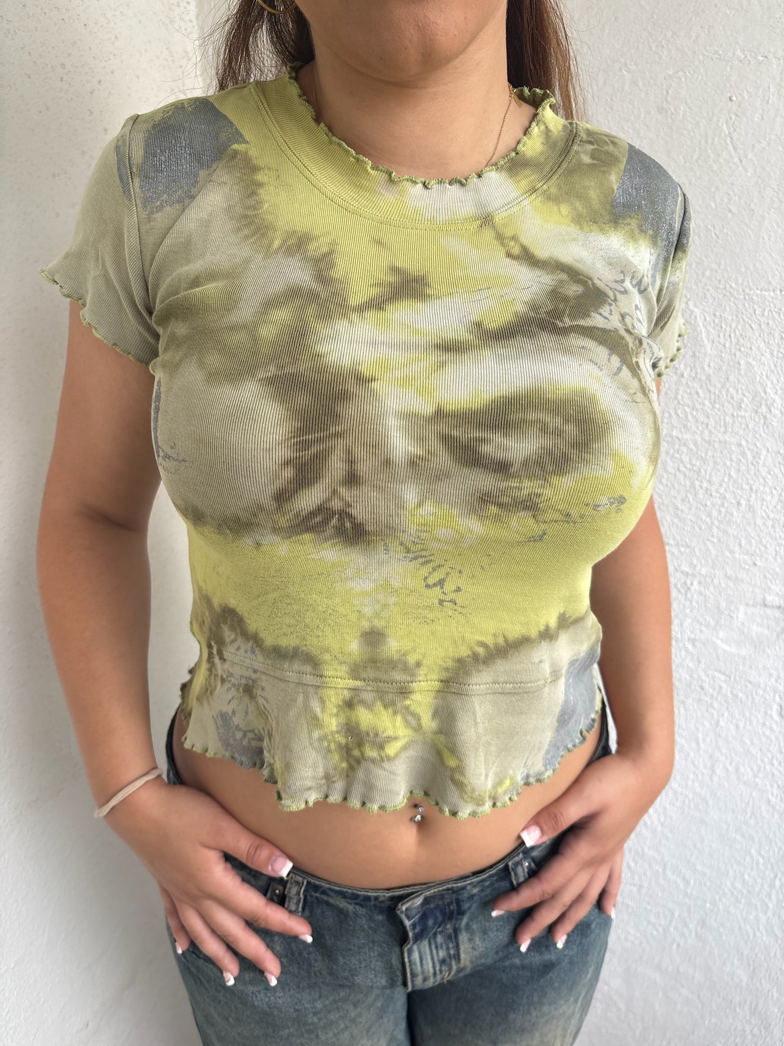 Woman Dressed in Y2K 00s Green and grey tie dye baby t-shirt featuring a stunning marble-style pattern throughout.