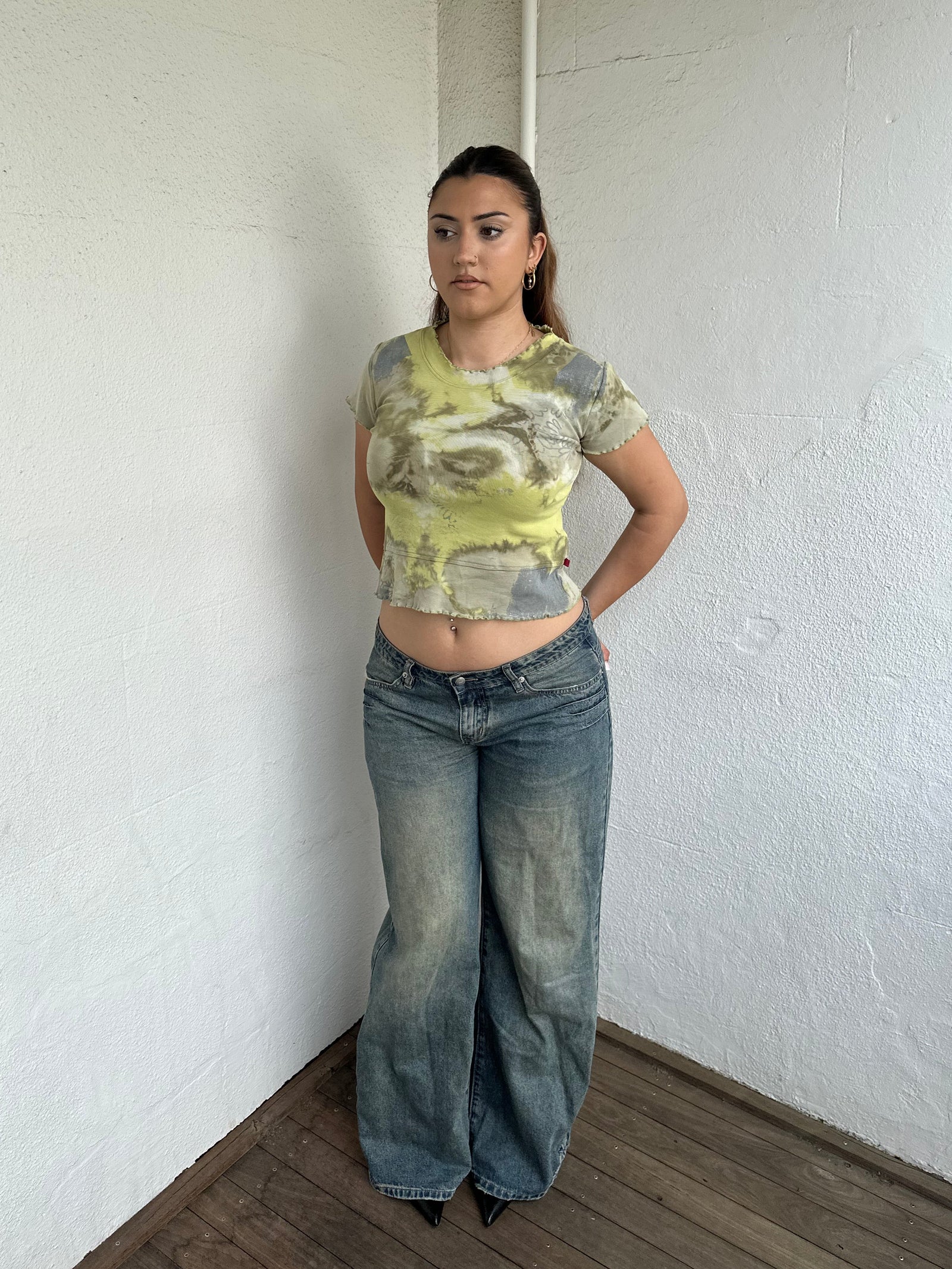 Woman Dressed in Y2K 00s Green and grey tie dye baby t-shirt featuring a stunning marble-style pattern throughout. 