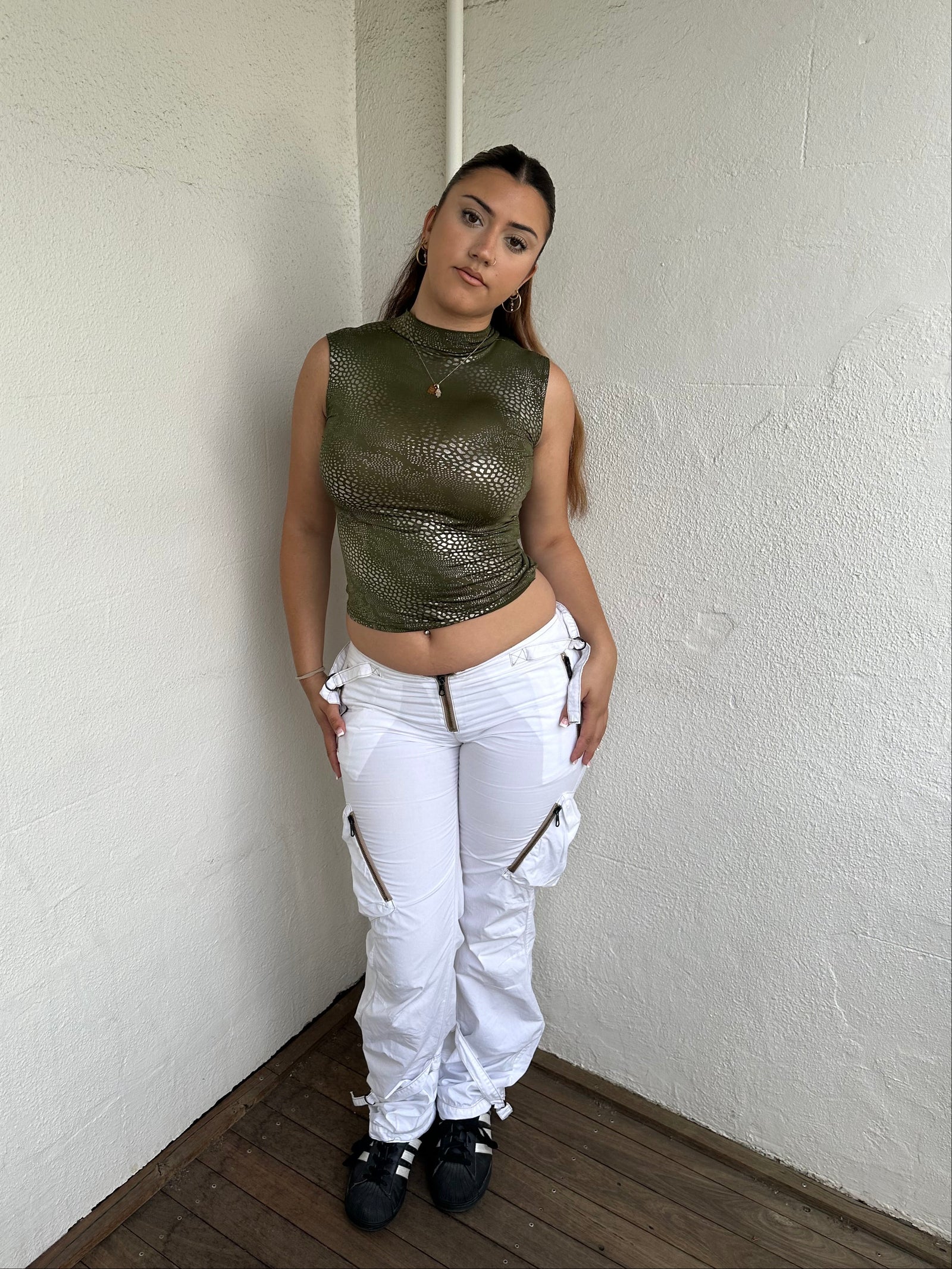 Woman Dressed in Y2K 00s Green and silver snake print tank top featuring a shimmering snake print throughout.