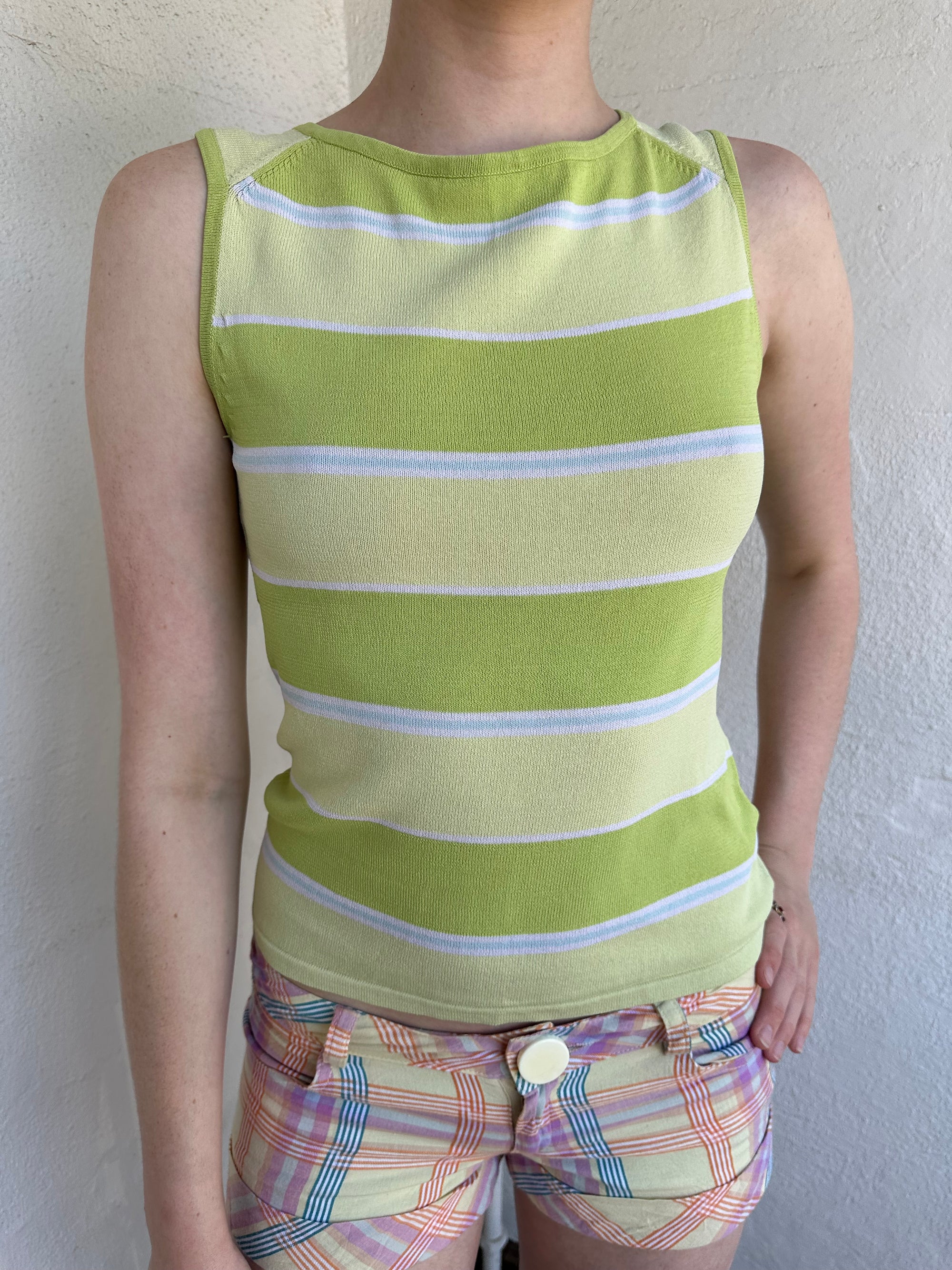 Woman Dressed in Y2K Green stripe knitted tank top featuring alternating horizontal stripes in pastel green and lime green 