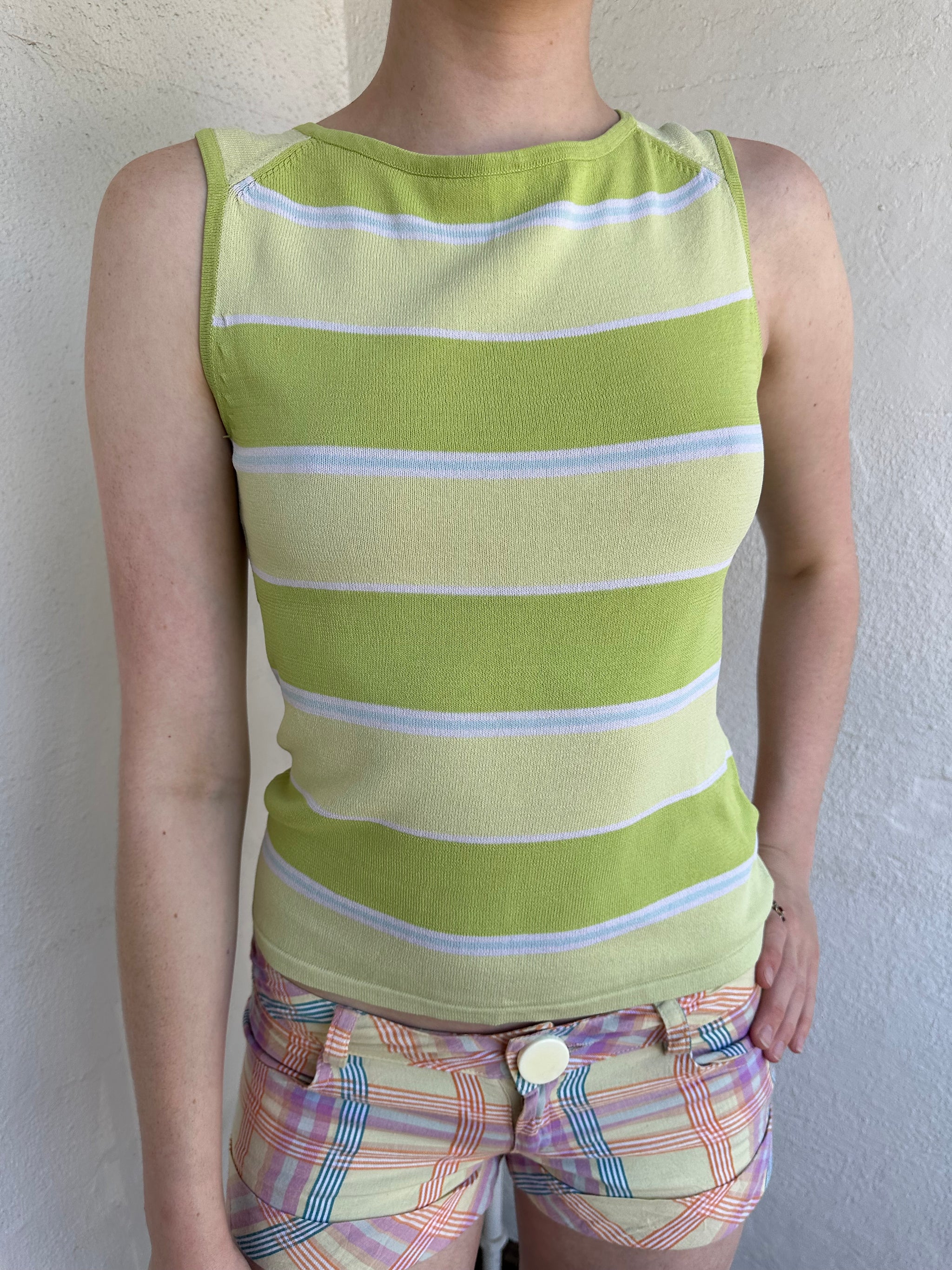 Woman Dressed in Y2K Green stripe knitted tank top featuring alternating horizontal stripes in pastel green and lime green 