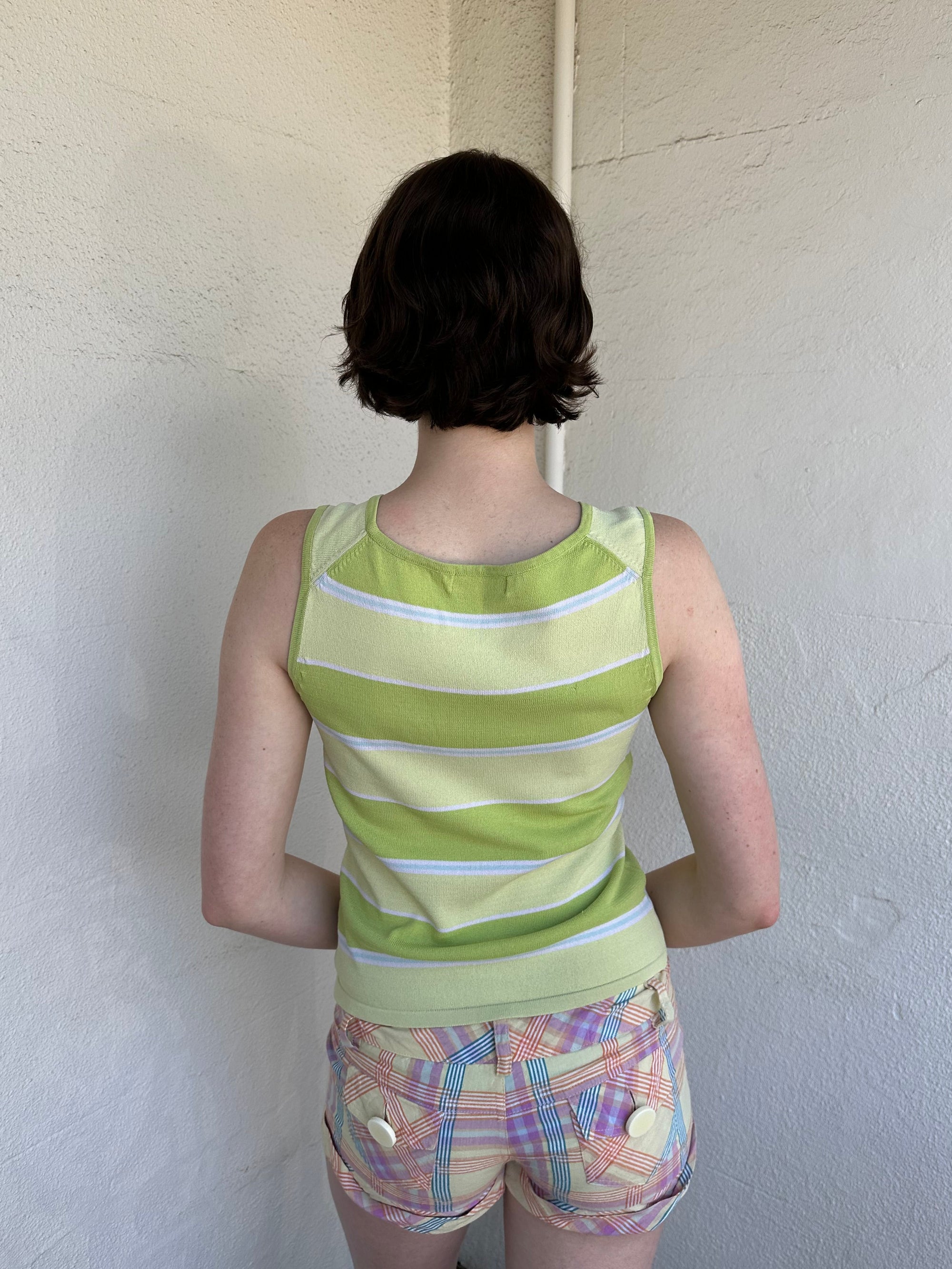 Woman Dressed in Y2K Green stripe knitted tank top featuring alternating horizontal stripes in pastel green and lime green 