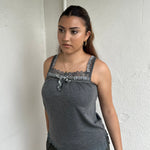 Woman Dressed in Y2K 00s Grey lace trimmed cami featuring a soft grey jersey material with lace trim along the neckline. 