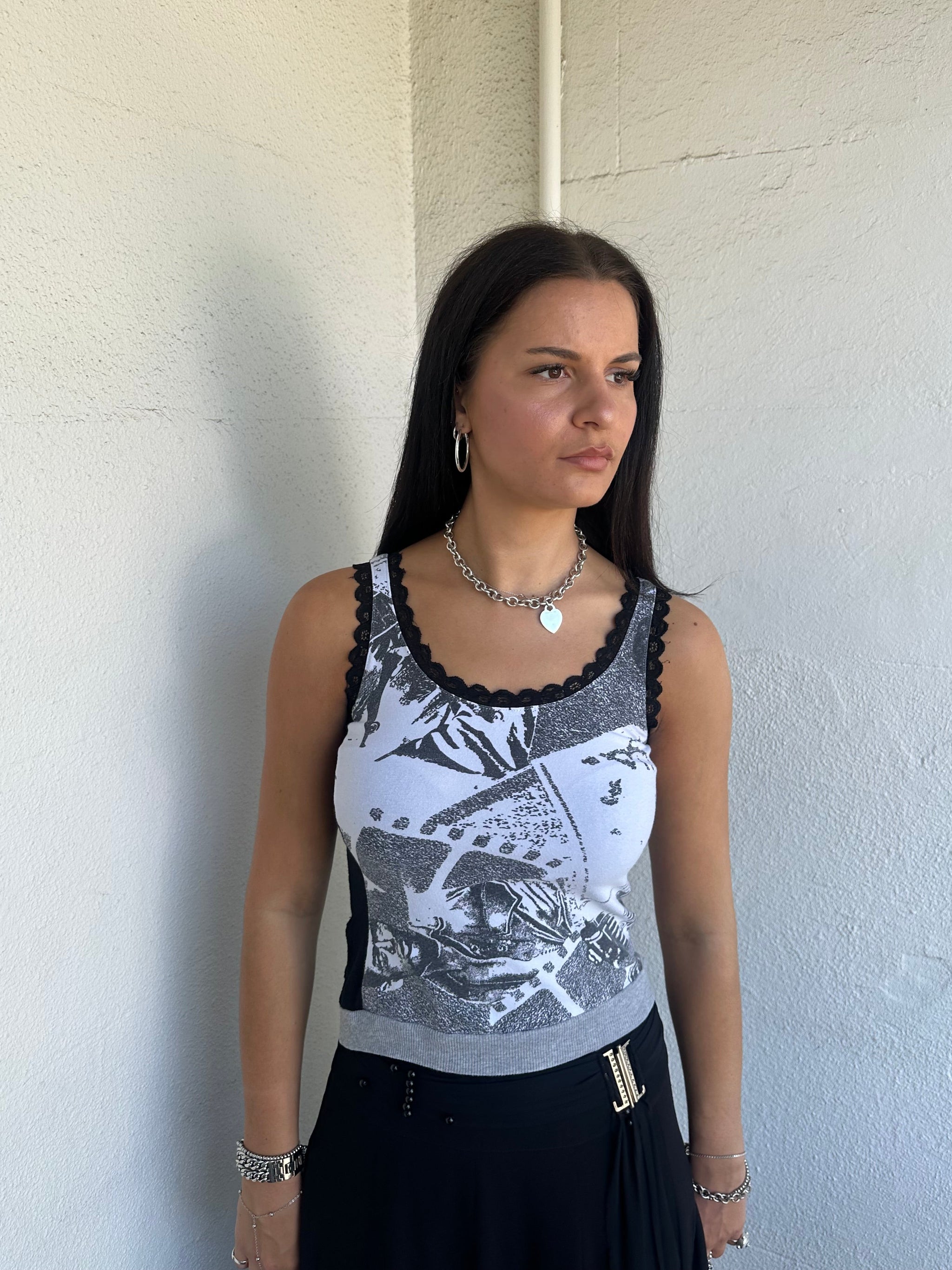 Woman Dressed in Y2K 00s Grey graphic tank top featuring a grey base with white and black graphic print on the front.