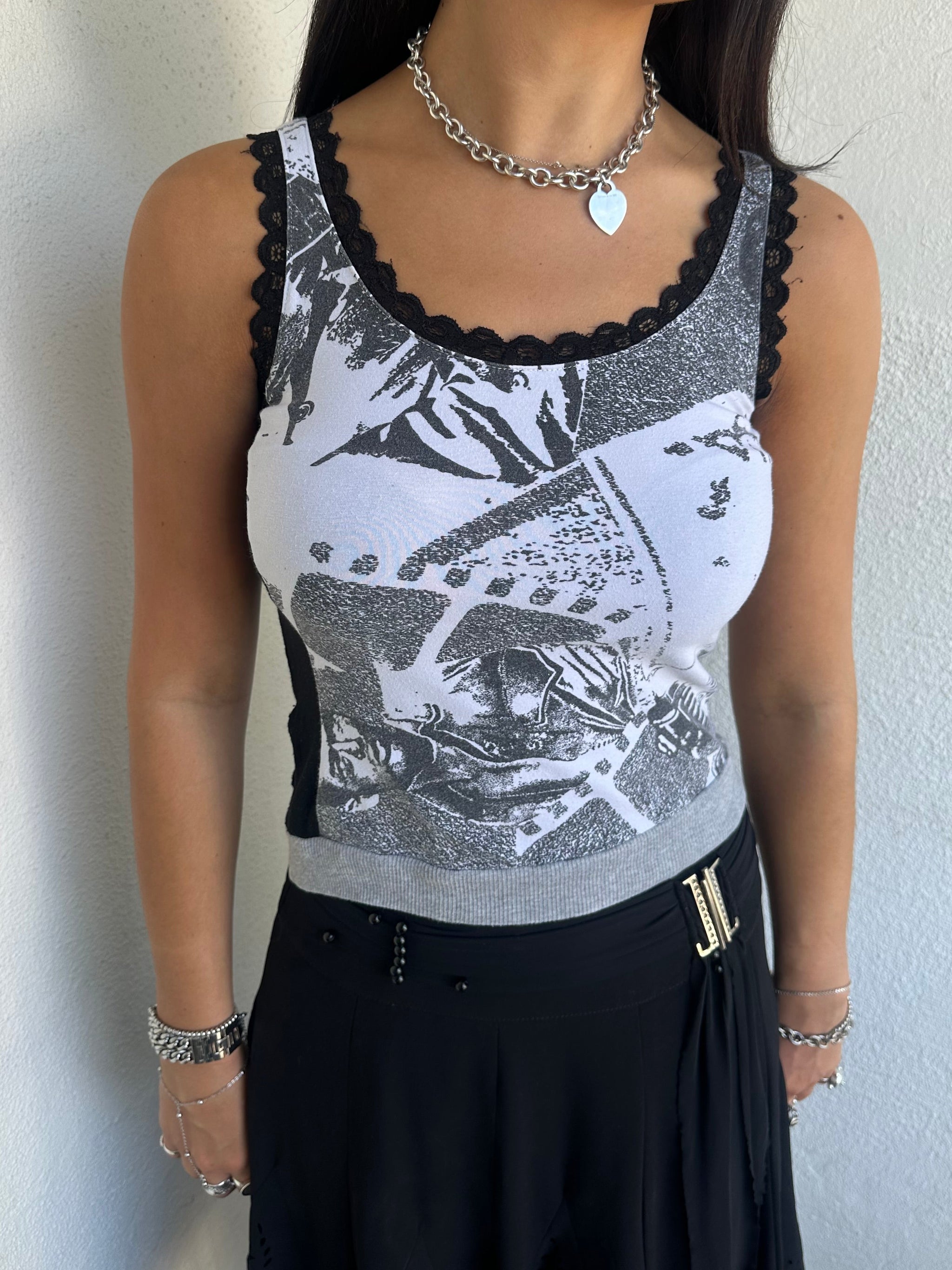 Woman Dressed in Y2K 00s Grey graphic tank top featuring a grey base with white and black graphic print on the front.