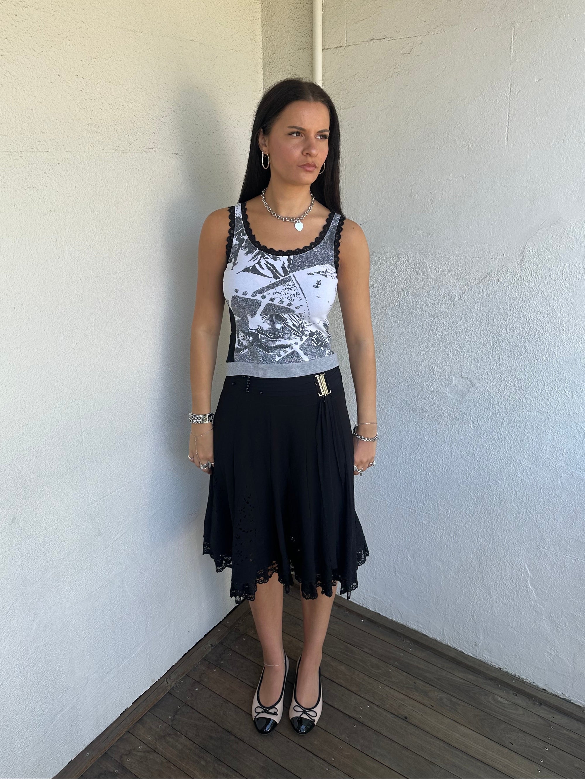Woman Dressed in Y2K 00s Grey graphic tank top featuring a grey base with white and black graphic print on the front.