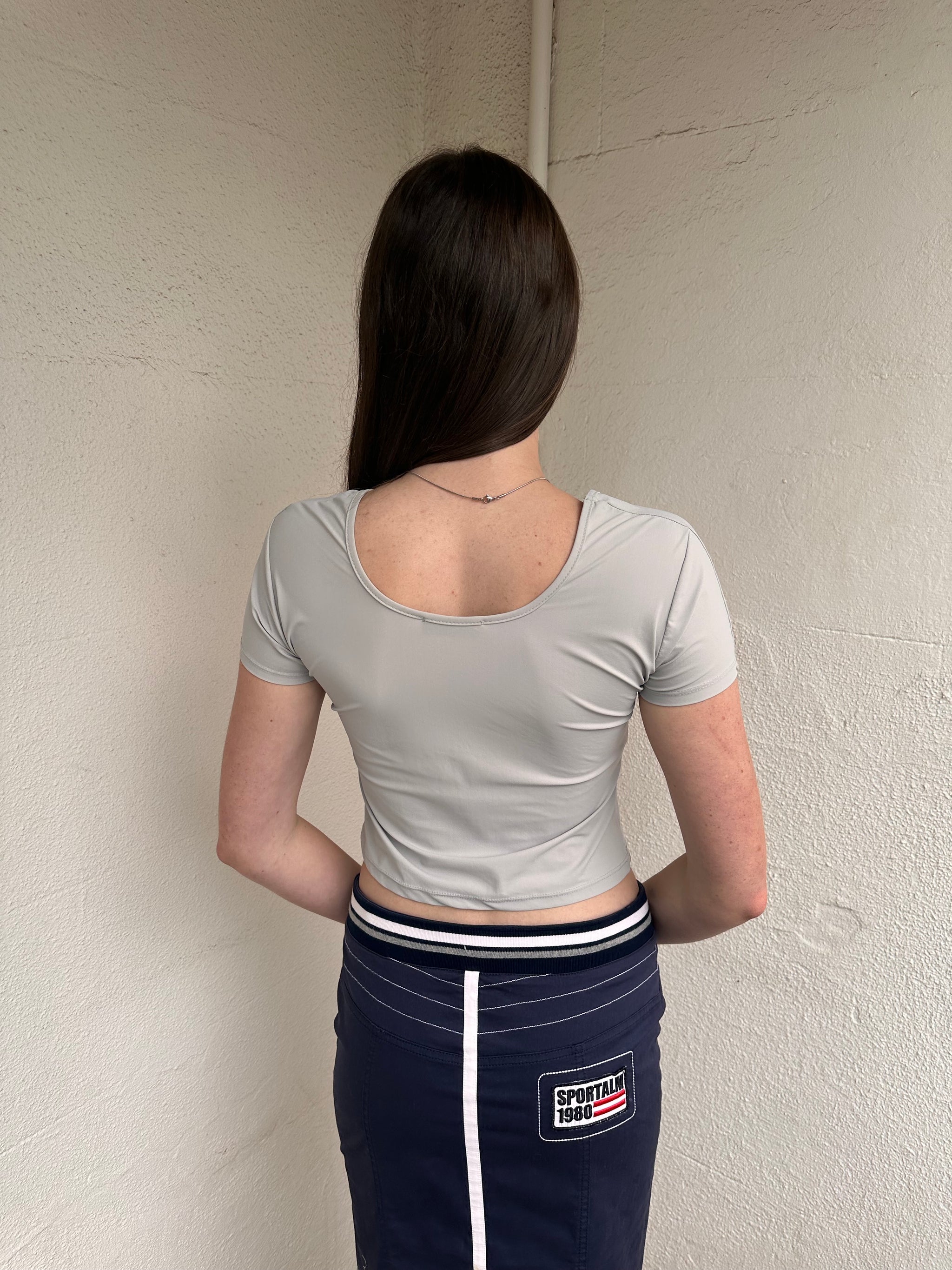 Woman wearing a Y2K 00s Grey baby t-shirt featuring an all-over Japanese symbol print