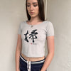 Woman wearing a Y2K 00s Grey baby t-shirt featuring an all-over Japanese symbol print