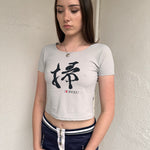 Woman wearing a Y2K 00s Grey baby t-shirt featuring an all-over Japanese symbol print