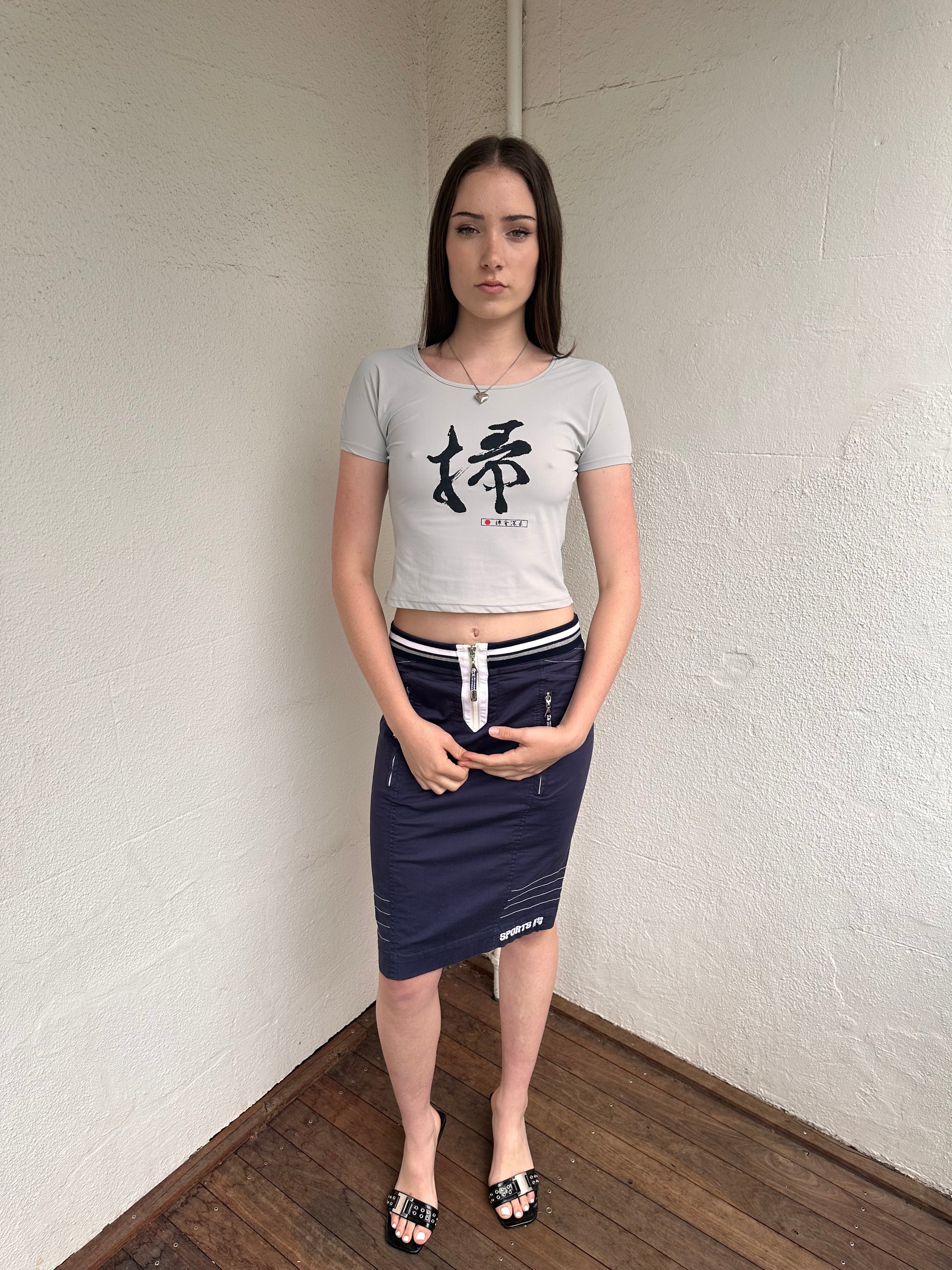 Woman wearing a Y2K 00s Grey baby t-shirt featuring an all-over Japanese symbol print