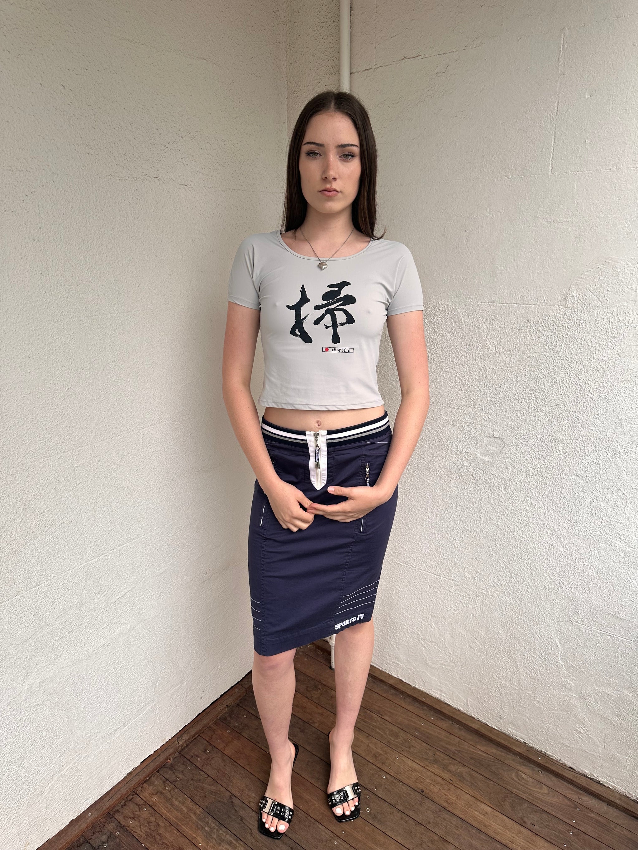 Woman wearing a Y2K 00s Grey baby t-shirt featuring an all-over Japanese symbol print