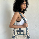 Woman wearing a Y2K 00s Guess cream and blue shoulder bag