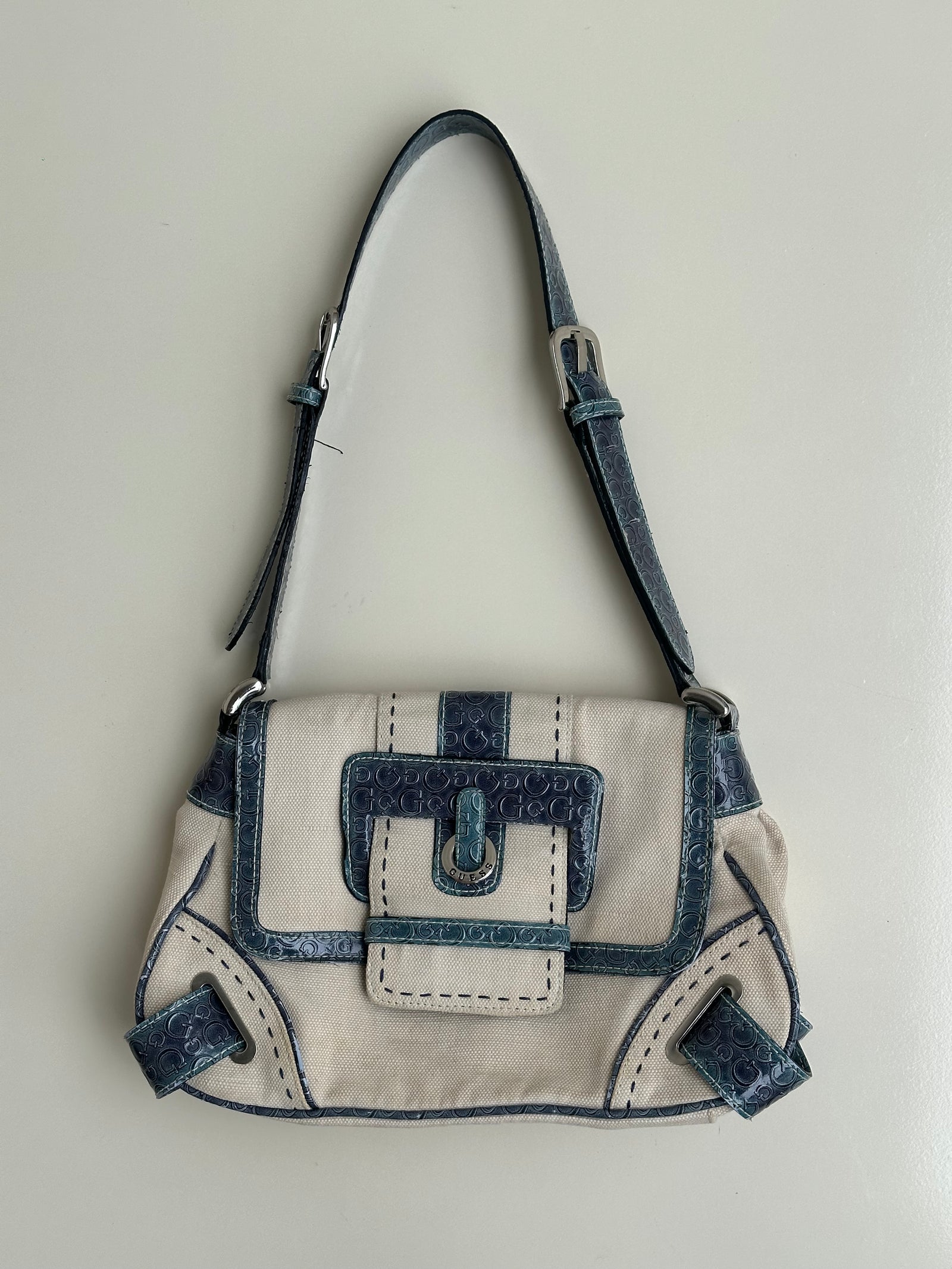 Woman wearing a Y2K 00s Guess cream and blue shoulder bag