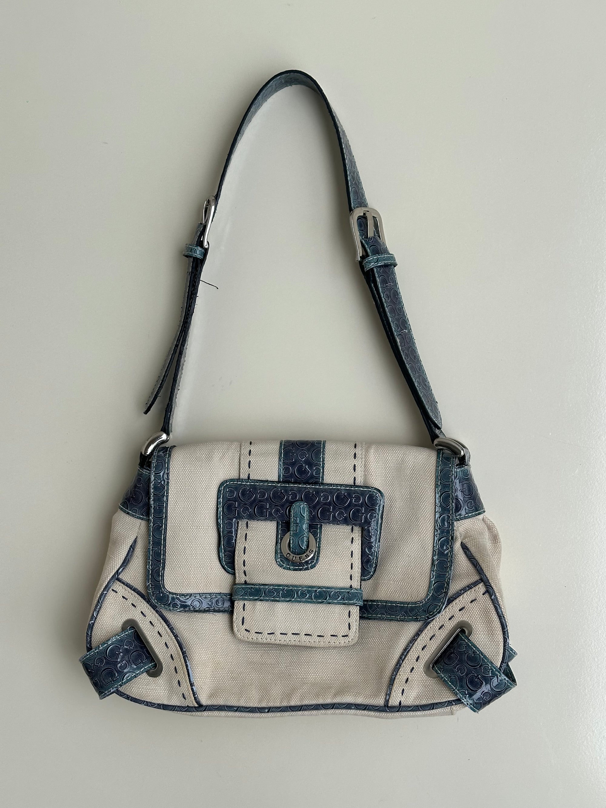 Woman wearing a Y2K 00s Guess cream and blue shoulder bag