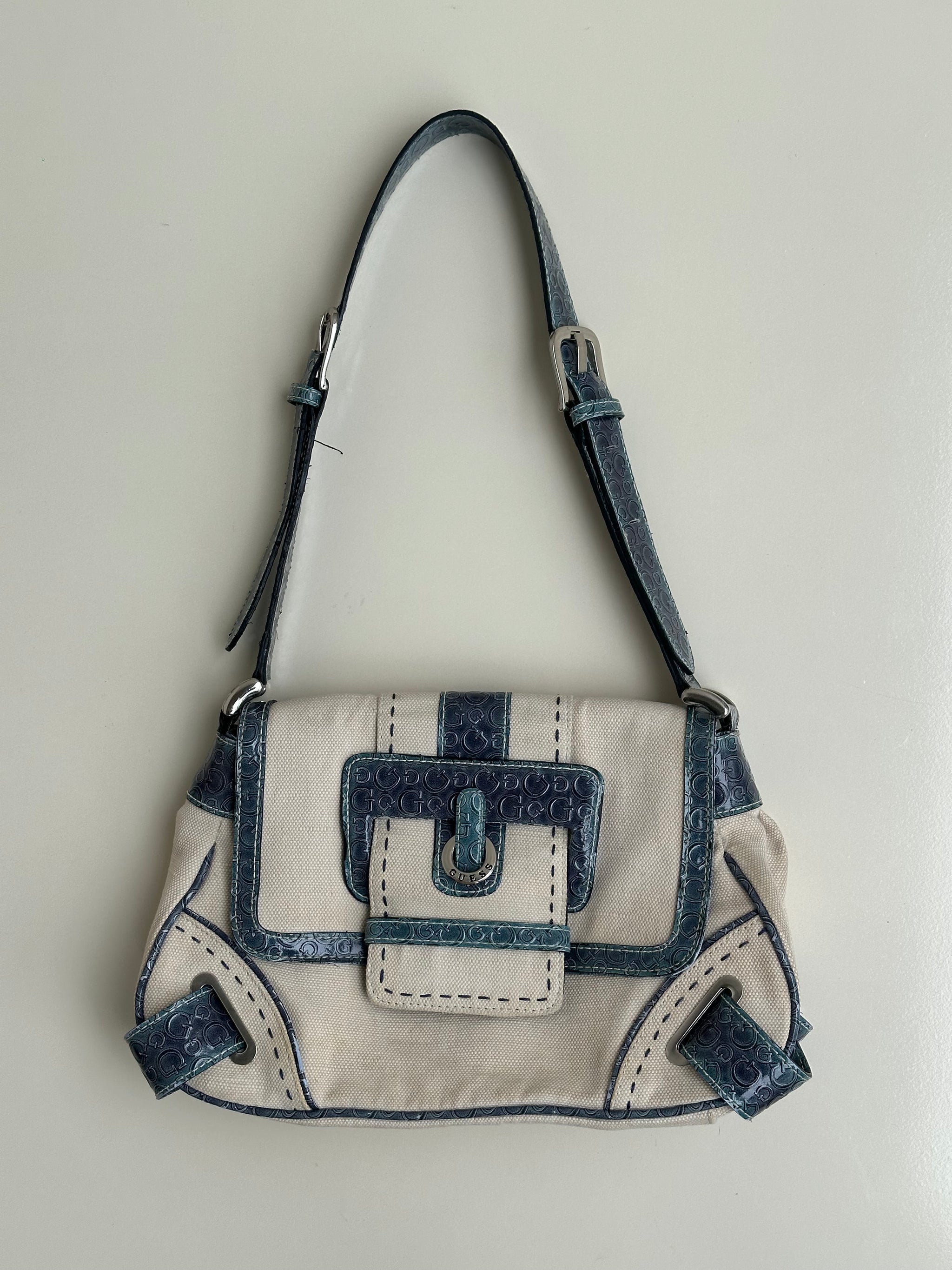 Woman wearing a Y2K 00s Guess cream and blue shoulder bag
