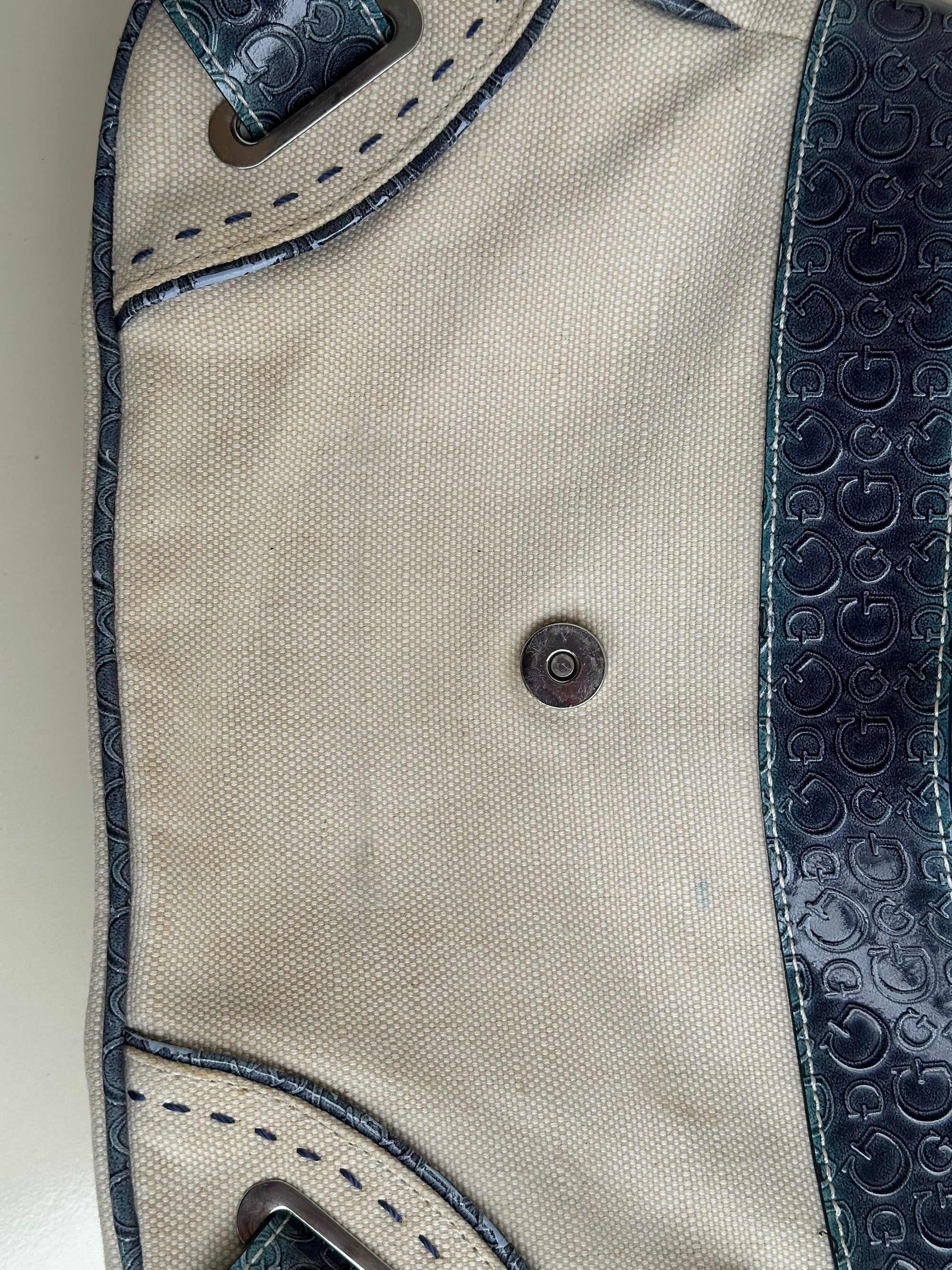 Woman wearing a Y2K 00s Guess cream and blue shoulder bag