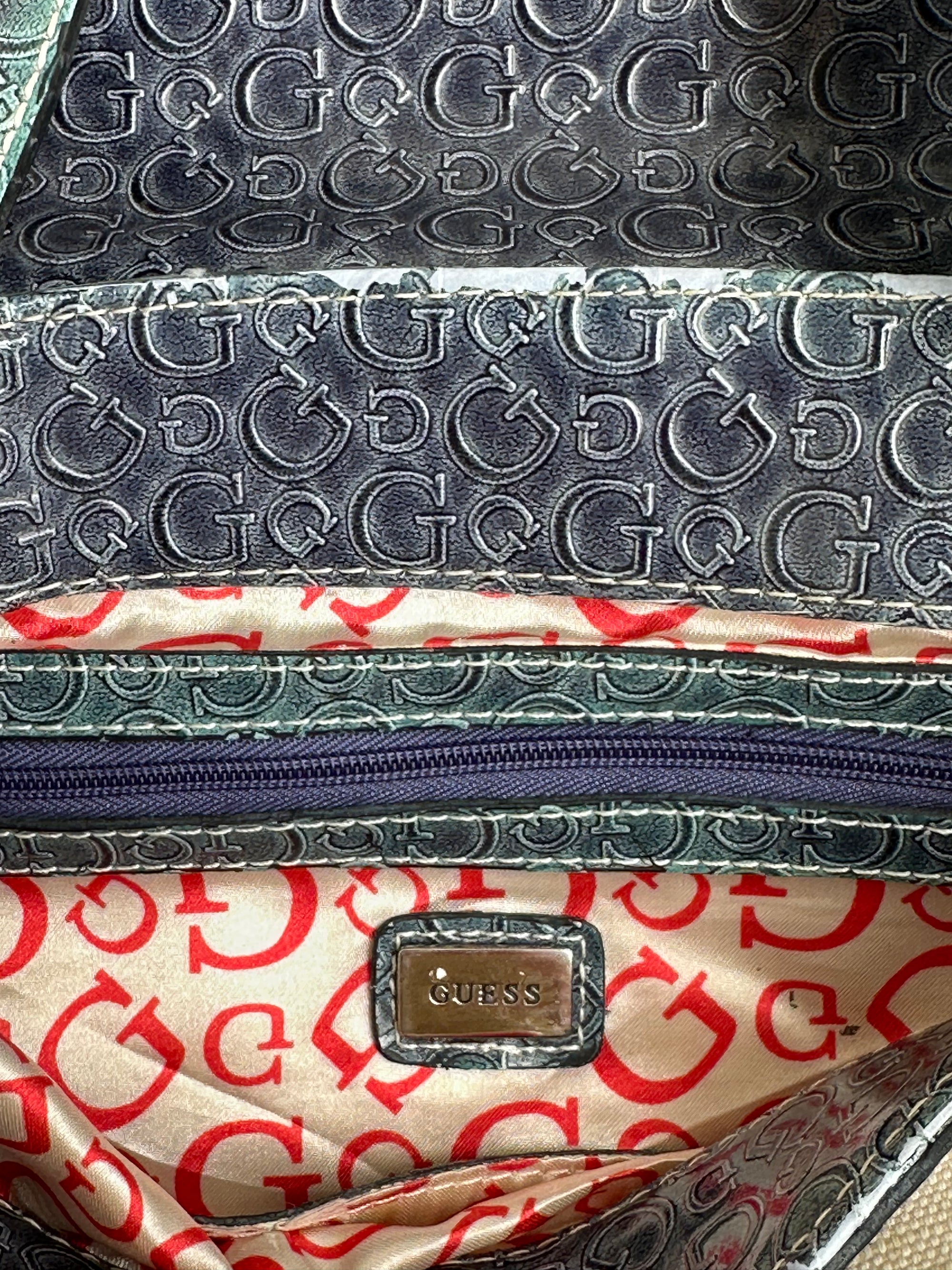 Woman wearing a Y2K 00s Guess cream and blue shoulder bag