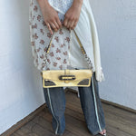 Women wearing a 00s Y2K Guess pastel yellow mini shoulder bag from the 2000s crafted from faux leather in a small rectangular shape.