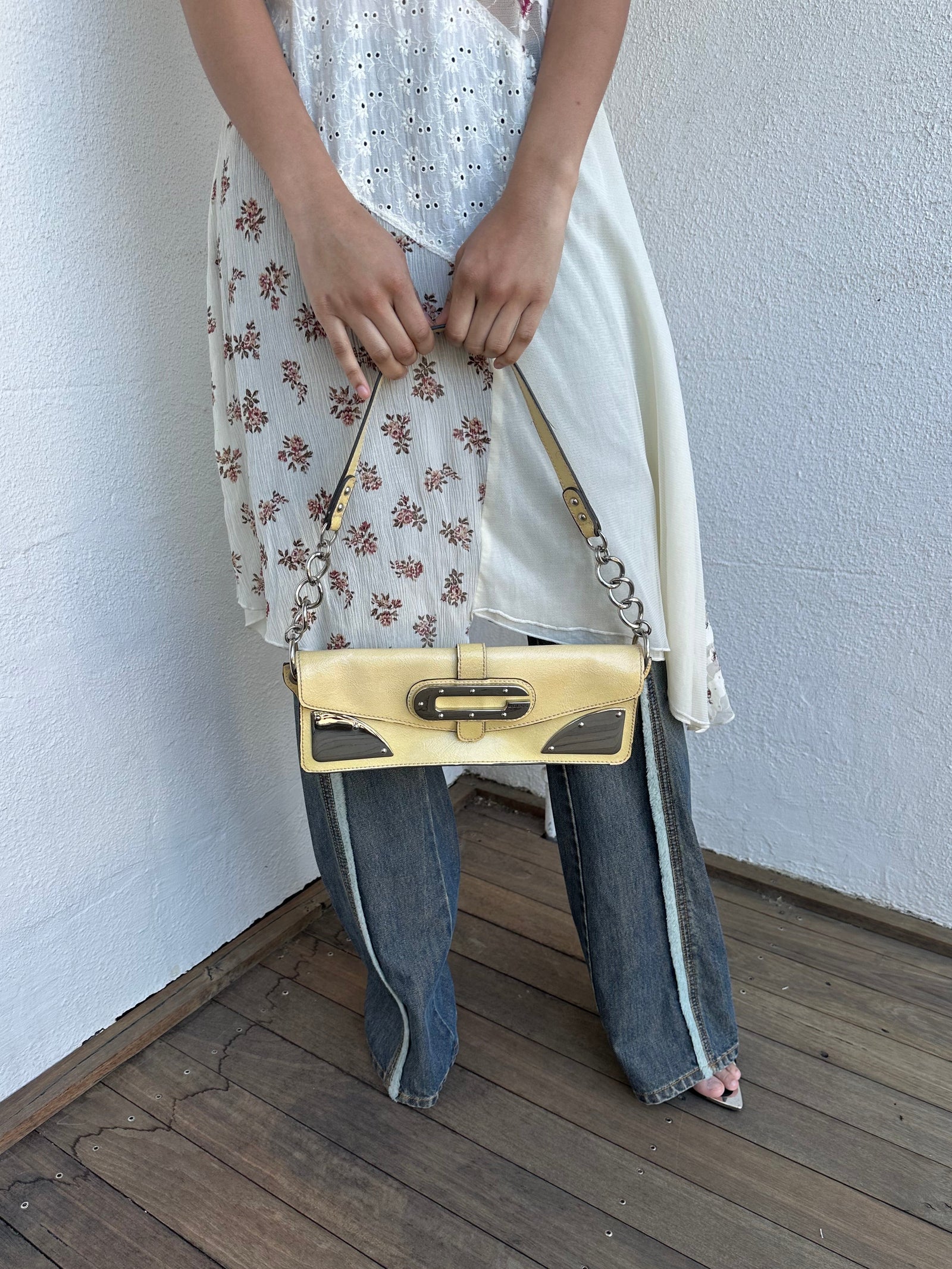 Women wearing a 00s Y2K Guess pastel yellow mini shoulder bag from the 2000s crafted from faux leather in a small rectangular shape.
