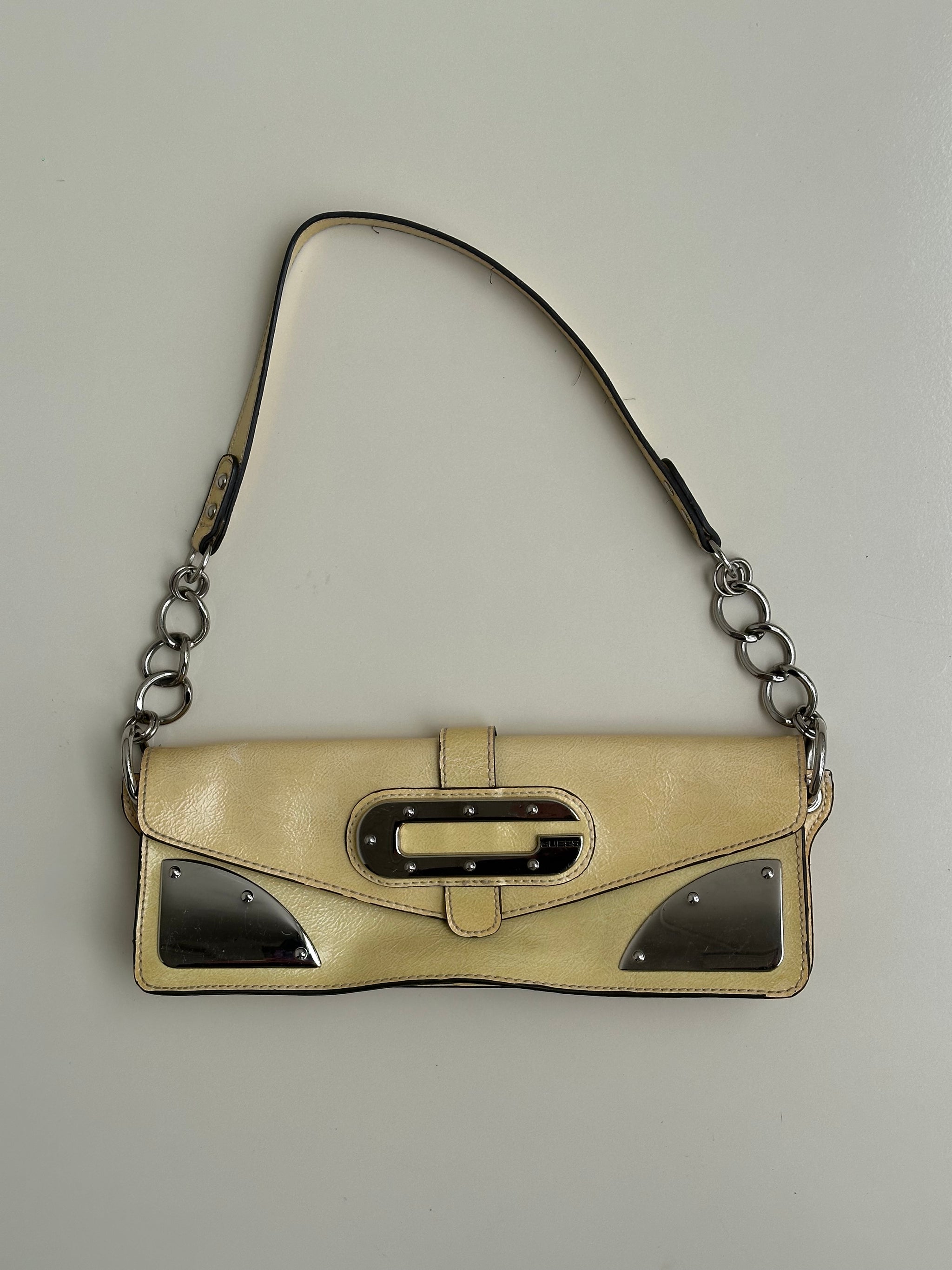 Women wearing a 00s Y2K Guess pastel yellow mini shoulder bag from the 2000s crafted from faux leather in a small rectangular shape.