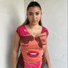 Woman Dressed in Y2K 00s Hot pink graphic t-shirt featuring an illustrated face graphic