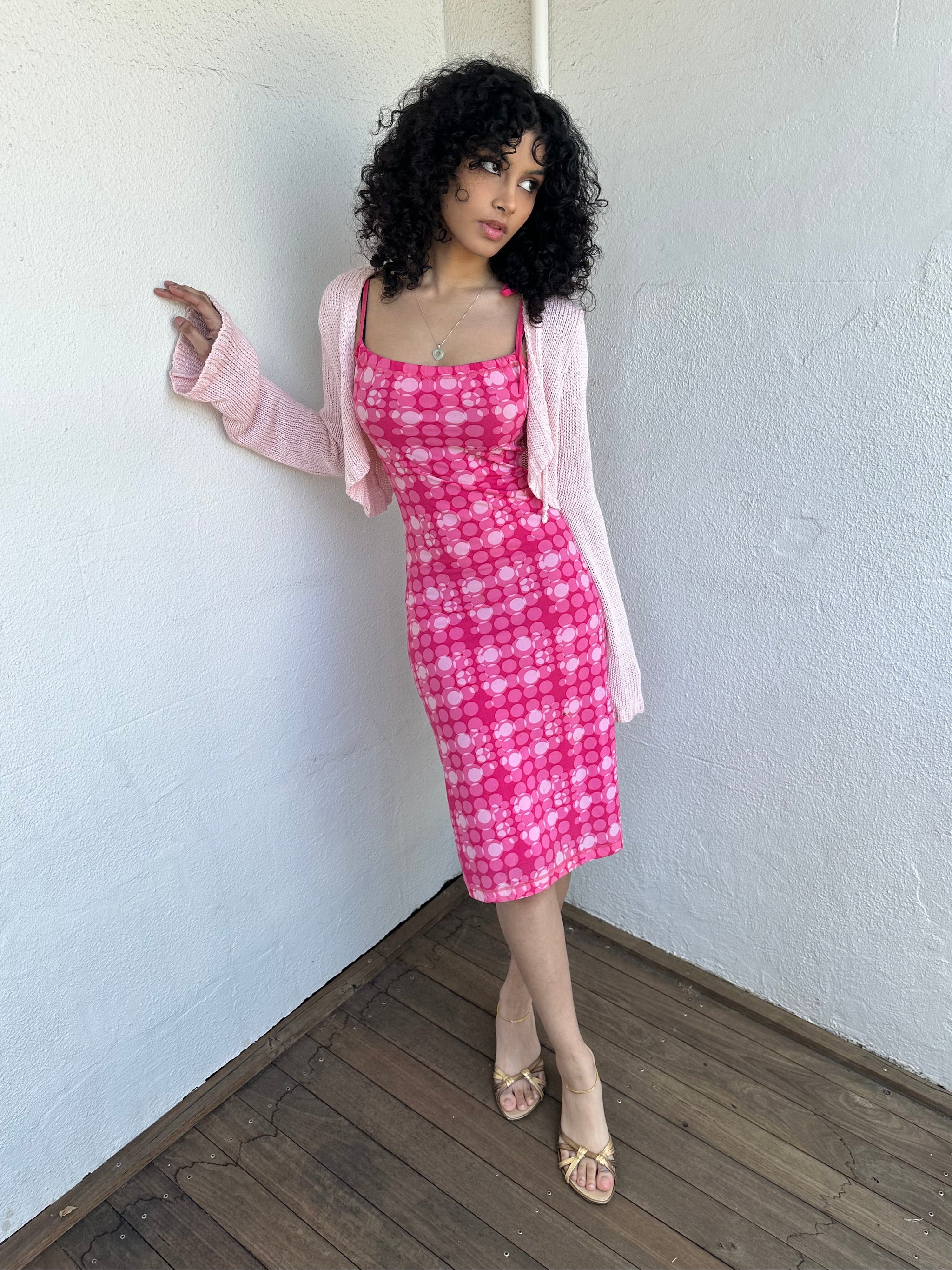 Woman wearing a Y2K 00s Hot pink groovy-style dress covered in bold white & baby pink polkadots.