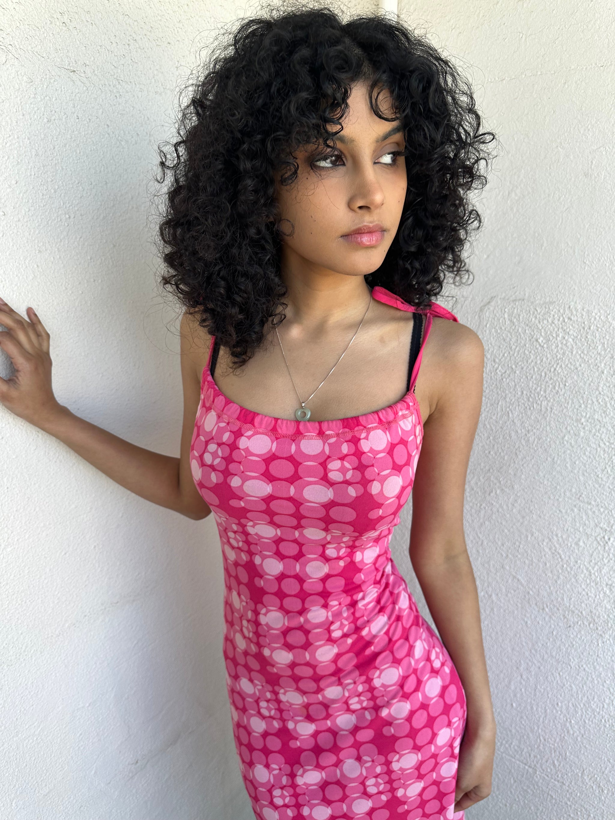 Woman wearing a Y2K 00s Hot pink groovy-style dress covered in bold white & baby pink polkadots.
