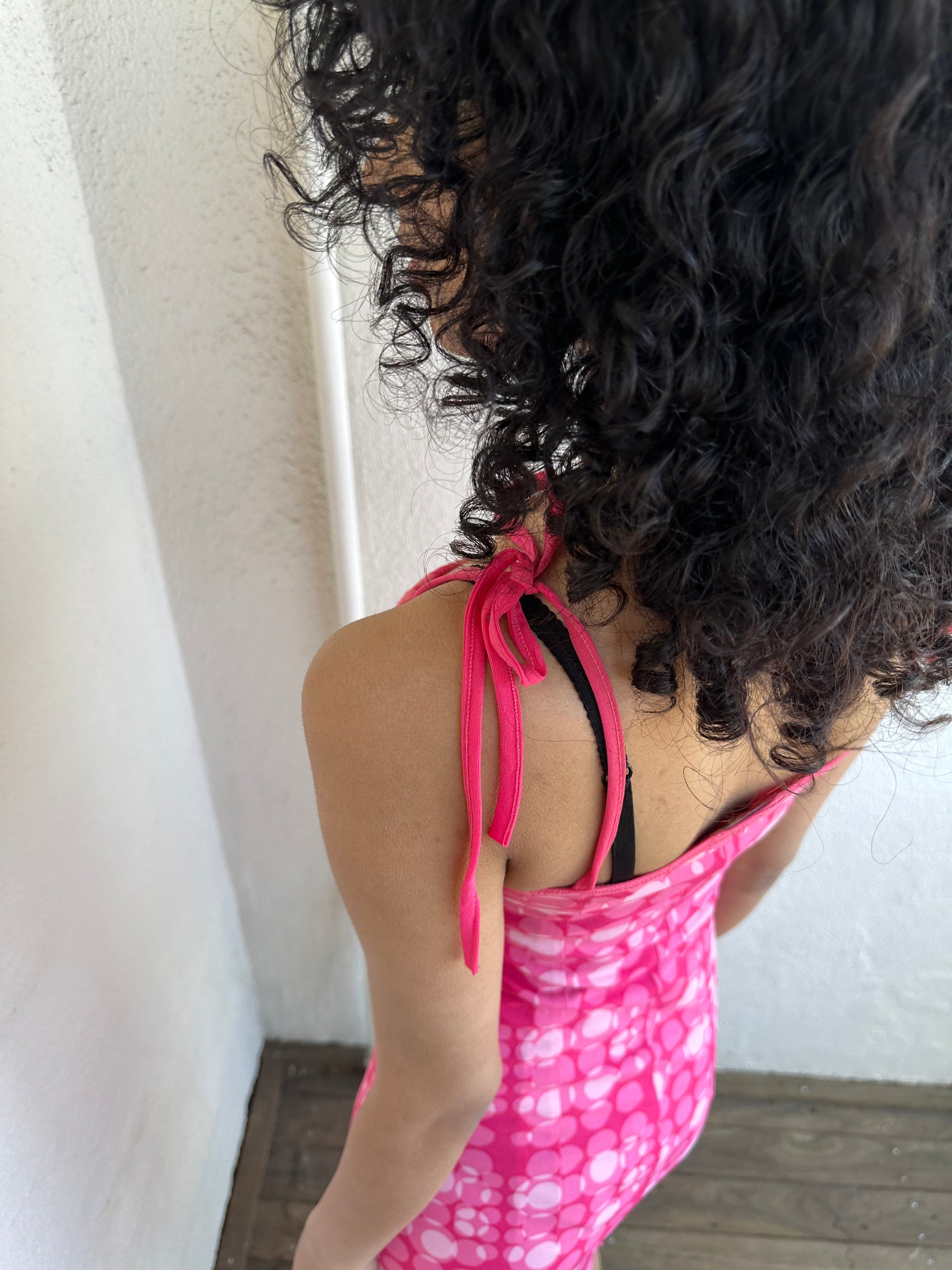 Woman wearing a Y2K 00s Hot pink groovy-style dress covered in bold white & baby pink polkadots.