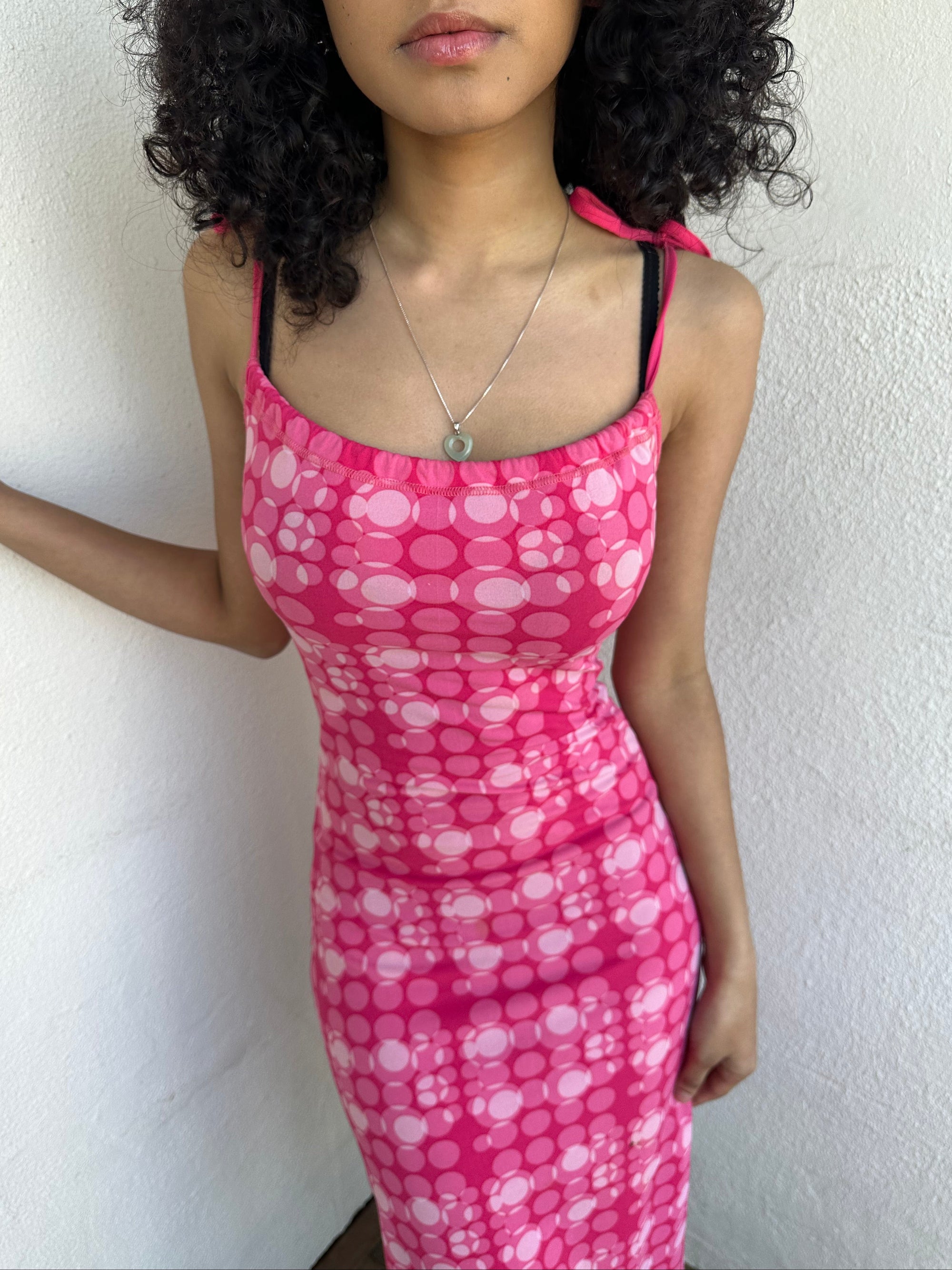 Woman wearing a Y2K 00s Hot pink groovy-style dress covered in bold white & baby pink polkadots.