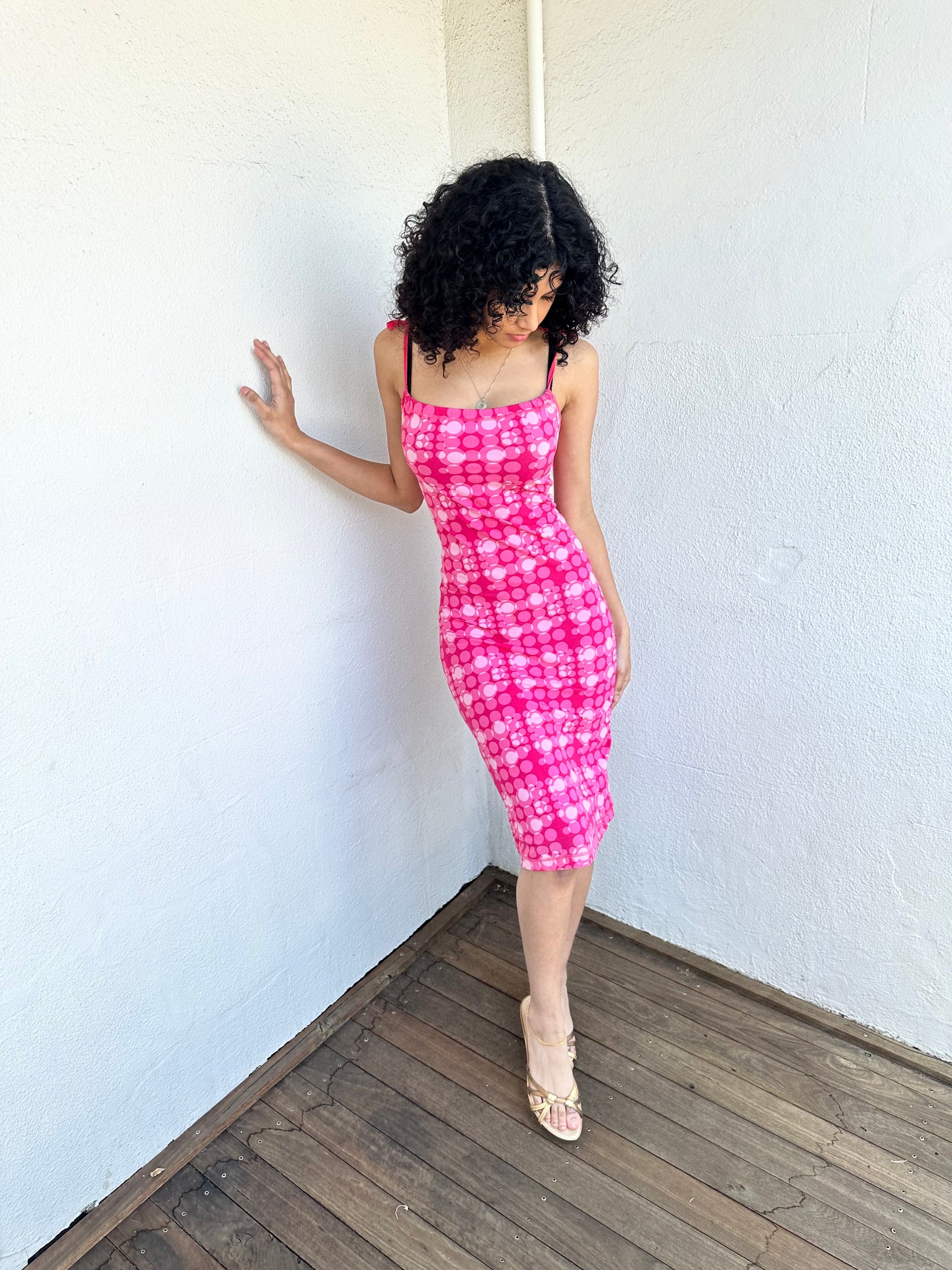 
Woman wearing a Y2K 00s Hot pink groovy-style dress covered in bold white & baby pink polkadots.