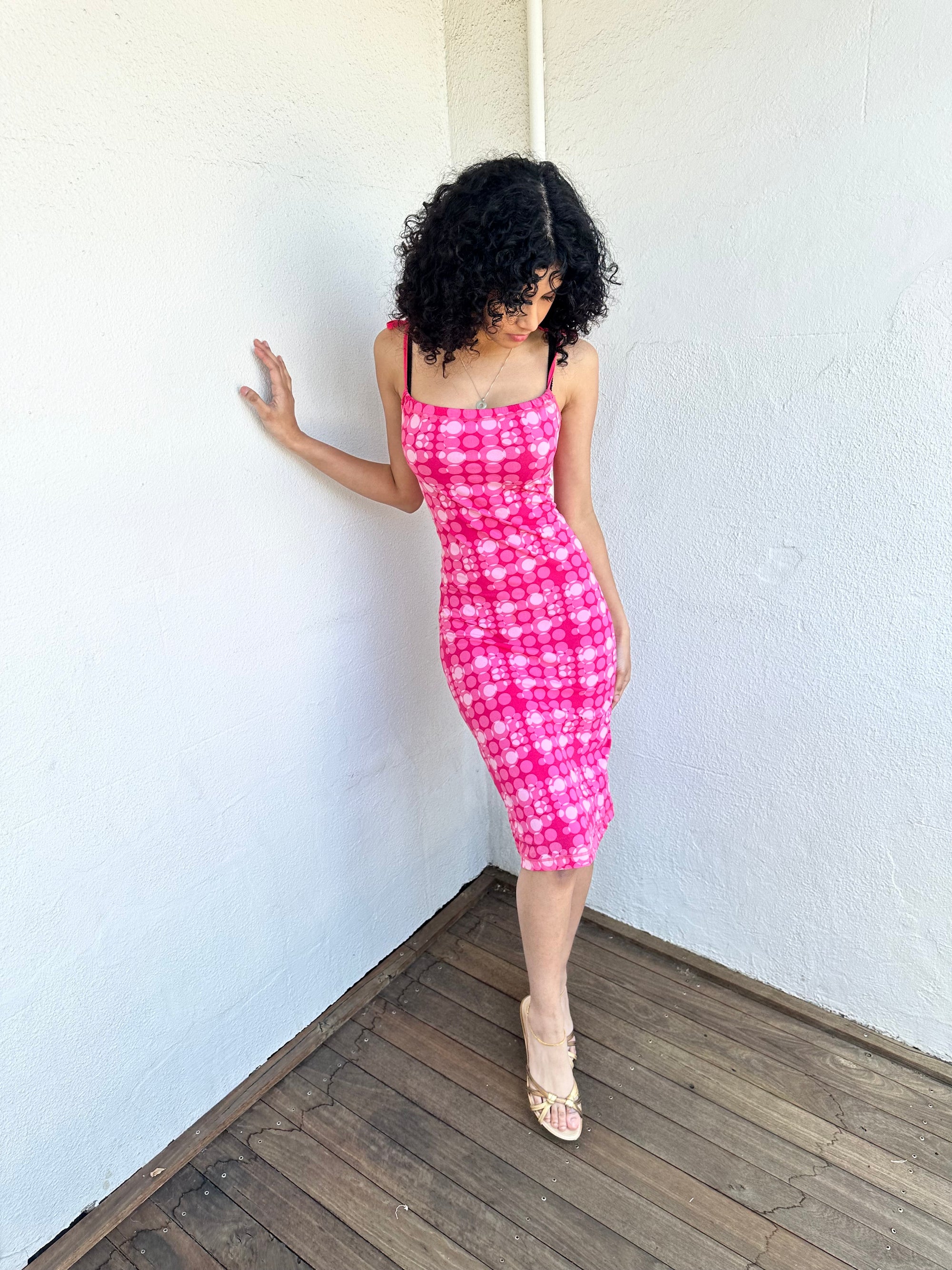 
Woman wearing a Y2K 00s Hot pink groovy-style dress covered in bold white & baby pink polkadots.