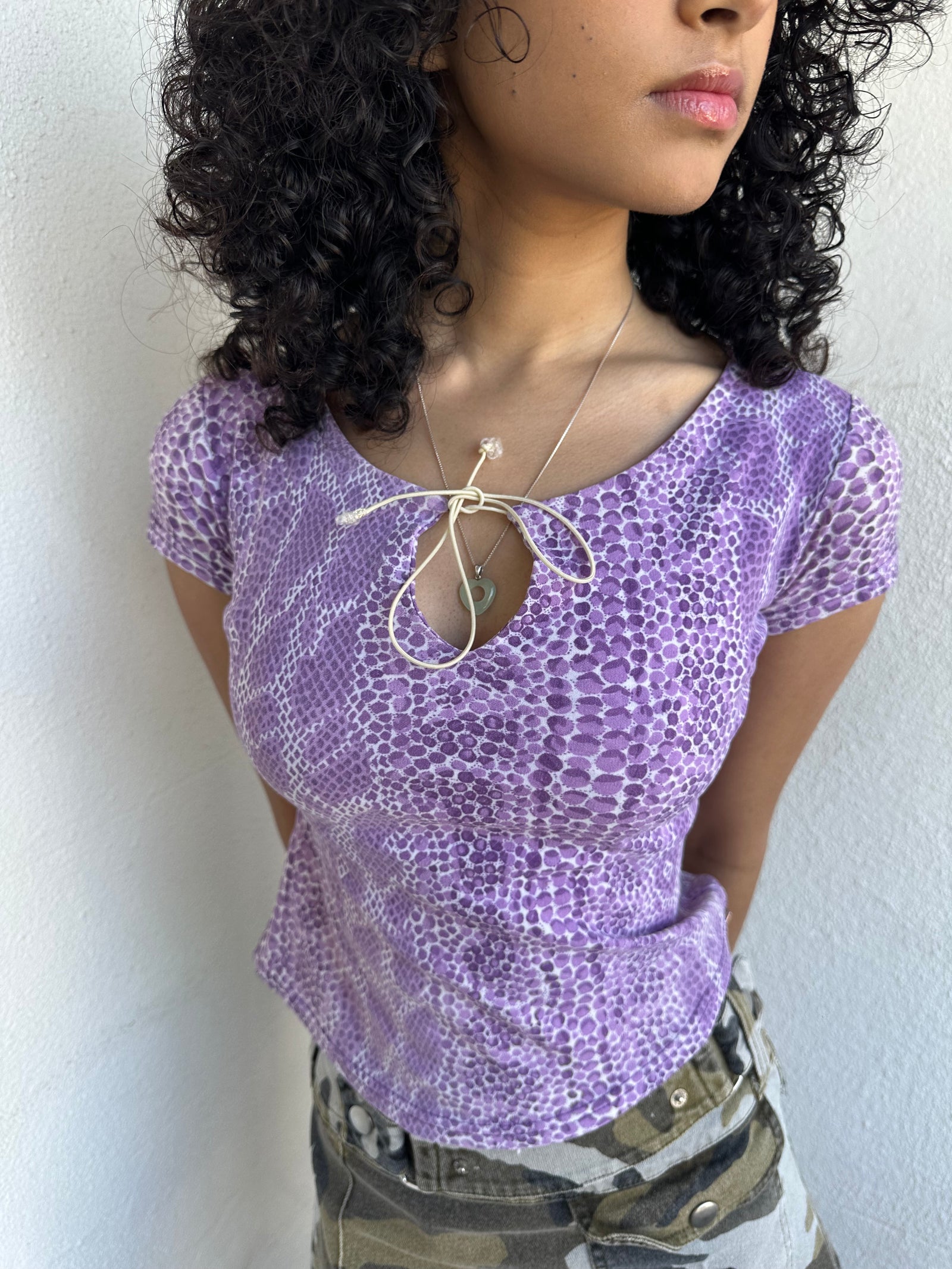 Women wearing a 00s Y2K Lilac snake print t-shirt featuring a keyhole front opening with adjustable tie design.