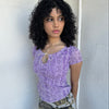 Women wearing a 00s Y2K Lilac snake print t-shirt featuring a keyhole front opening with adjustable tie design.