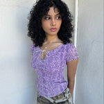 Women wearing a 00s Y2K Lilac snake print t-shirt featuring a keyhole front opening with adjustable tie design.