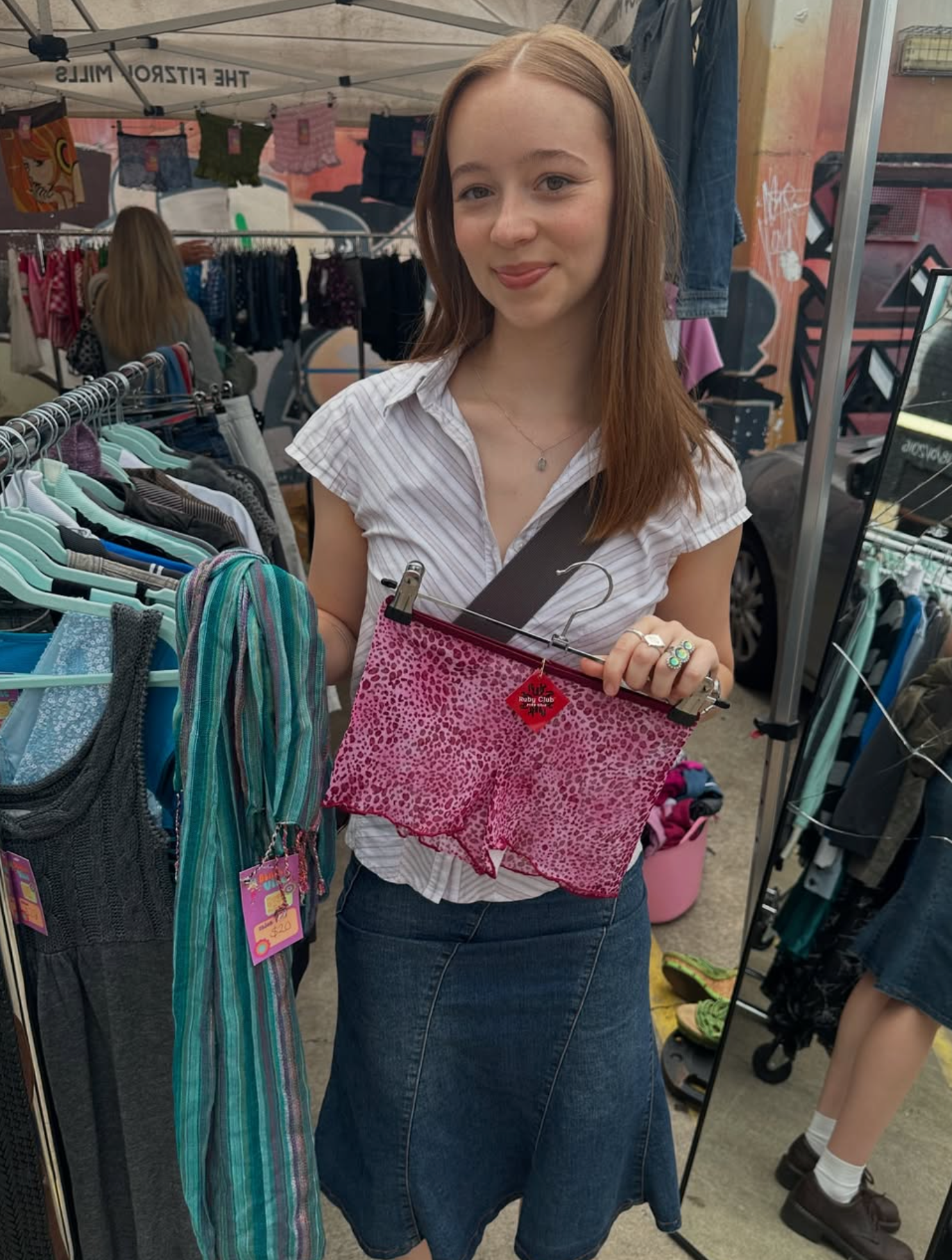 Woman holding a pink shorts in a market setting