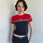 Woman Dressed in Y2K Miss Marines red & navy T-shirt featuring a classic crew neckline with contrasting colour-block panels for a sporty, vintage skater look.