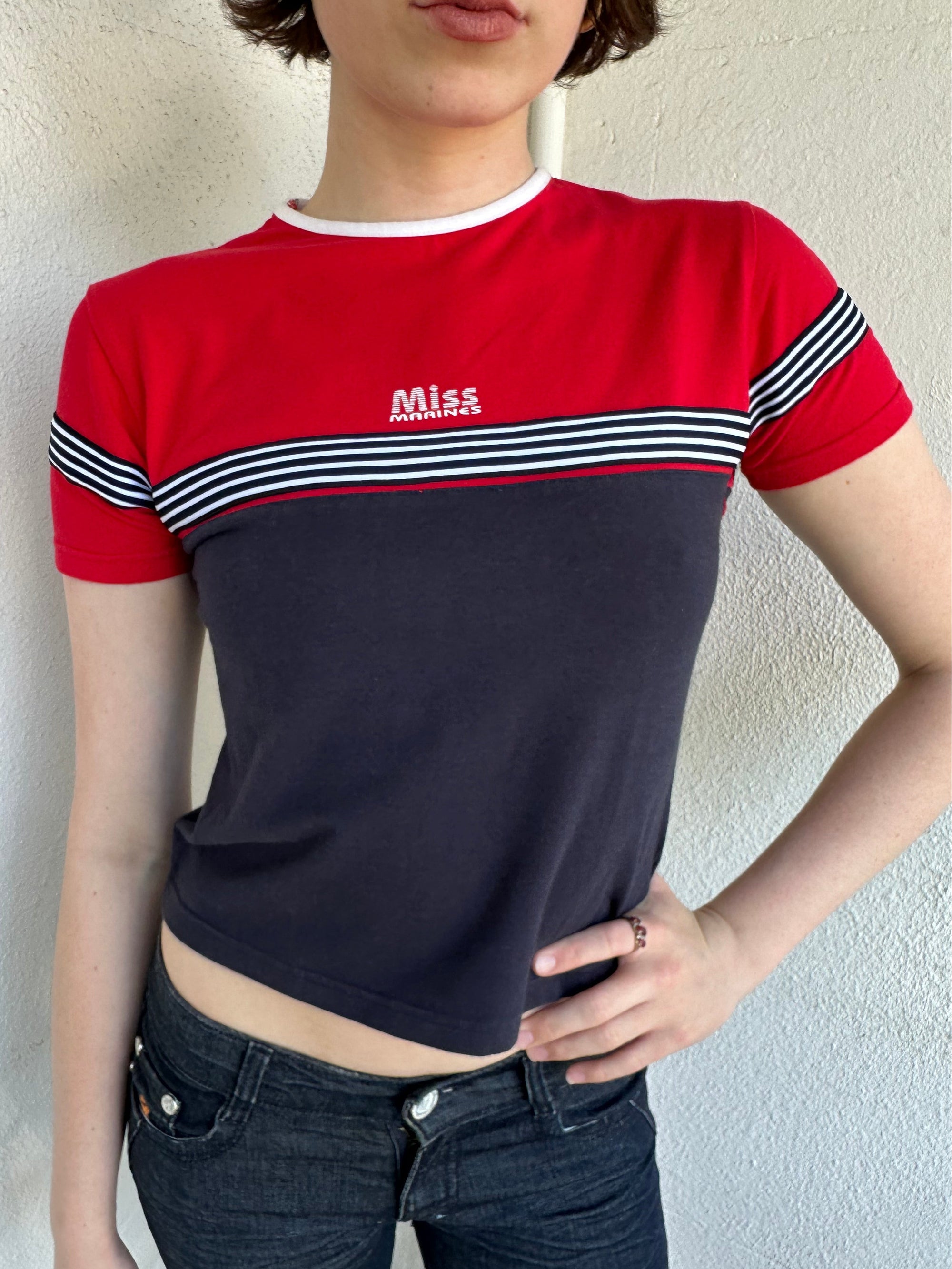Woman Dressed in Y2K Miss Marines red & navy T-shirt featuring a classic crew neckline with contrasting colour-block panels for a sporty, vintage skater look.