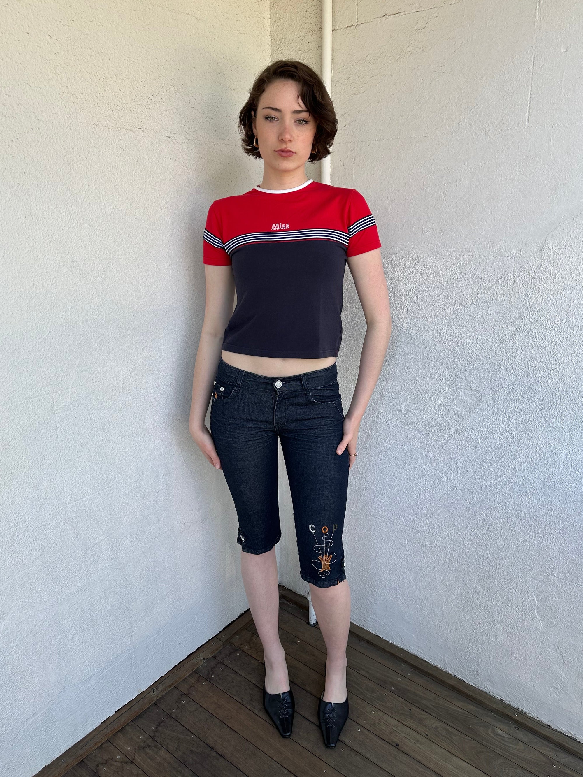 Woman Dressed in Y2K Miss Marines red & navy T-shirt featuring a classic crew neckline with contrasting colour-block panels for a sporty, vintage skater look.