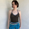 Woman Dressed in Y2K Multicoloured knitted halter top featuring a brown knitted body with contrasting blue and orange striped trim along the halter strap and hem.