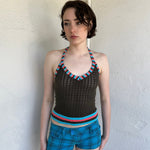 Woman Dressed in Y2K Multicoloured knitted halter top featuring a brown knitted body with contrasting blue and orange striped trim along the halter strap and hem.