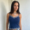 Woman Dressed in Y2K 00s Navy and white polkadot Y2K cami featuring a classic navy base with white polkadot detailing and lace trim along the bust.