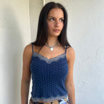 Woman Dressed in Y2K 00s Navy and white polkadot Y2K cami featuring a classic navy base with white polkadot detailing and lace trim along the bust.