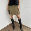 Woman Dressed in Y2K 00s Olive green mesh layered skirt featuring soft mesh layers with a side slit