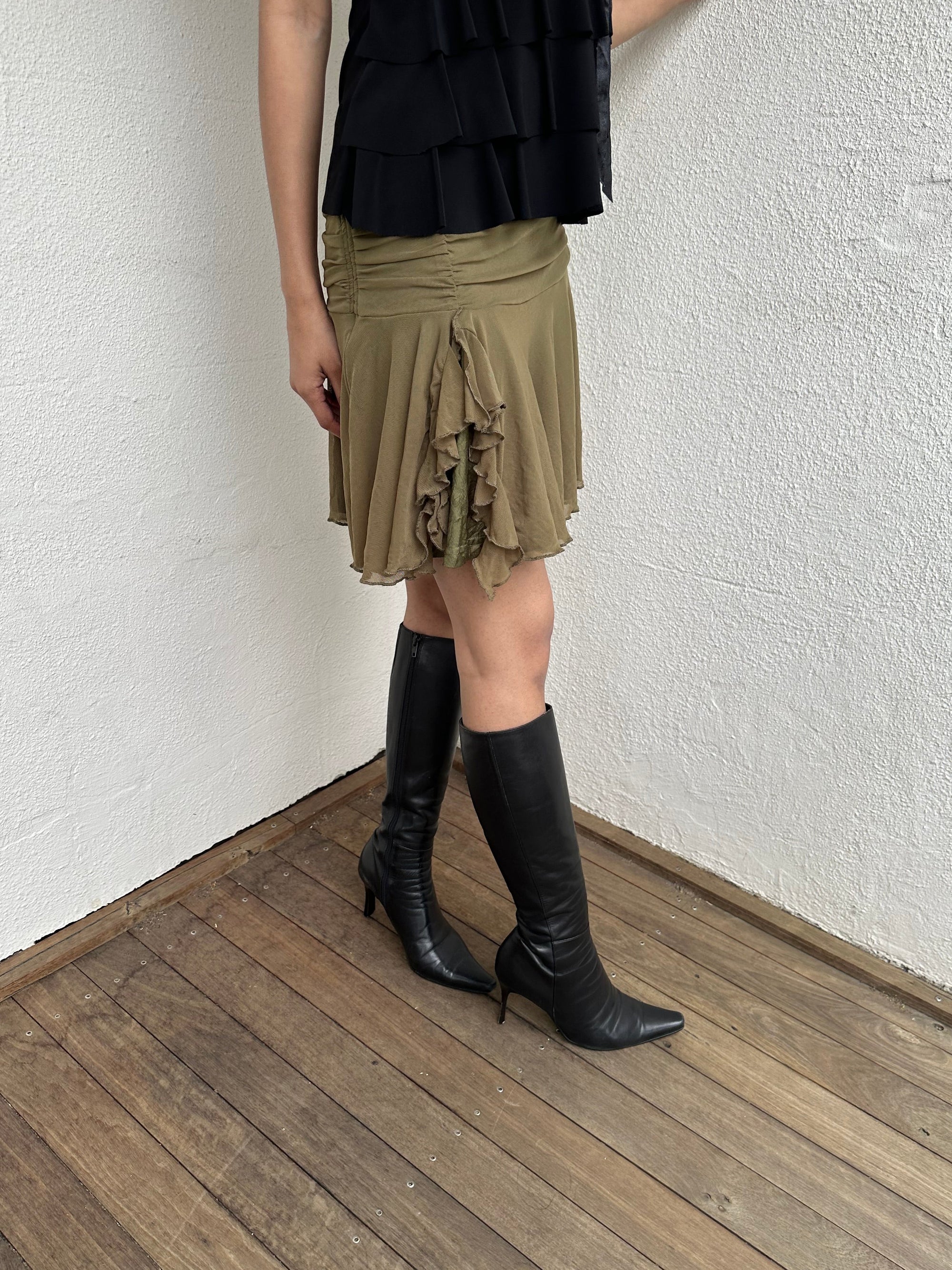Woman Dressed in Y2K 00s Olive green mesh layered skirt featuring soft mesh layers with a side slit