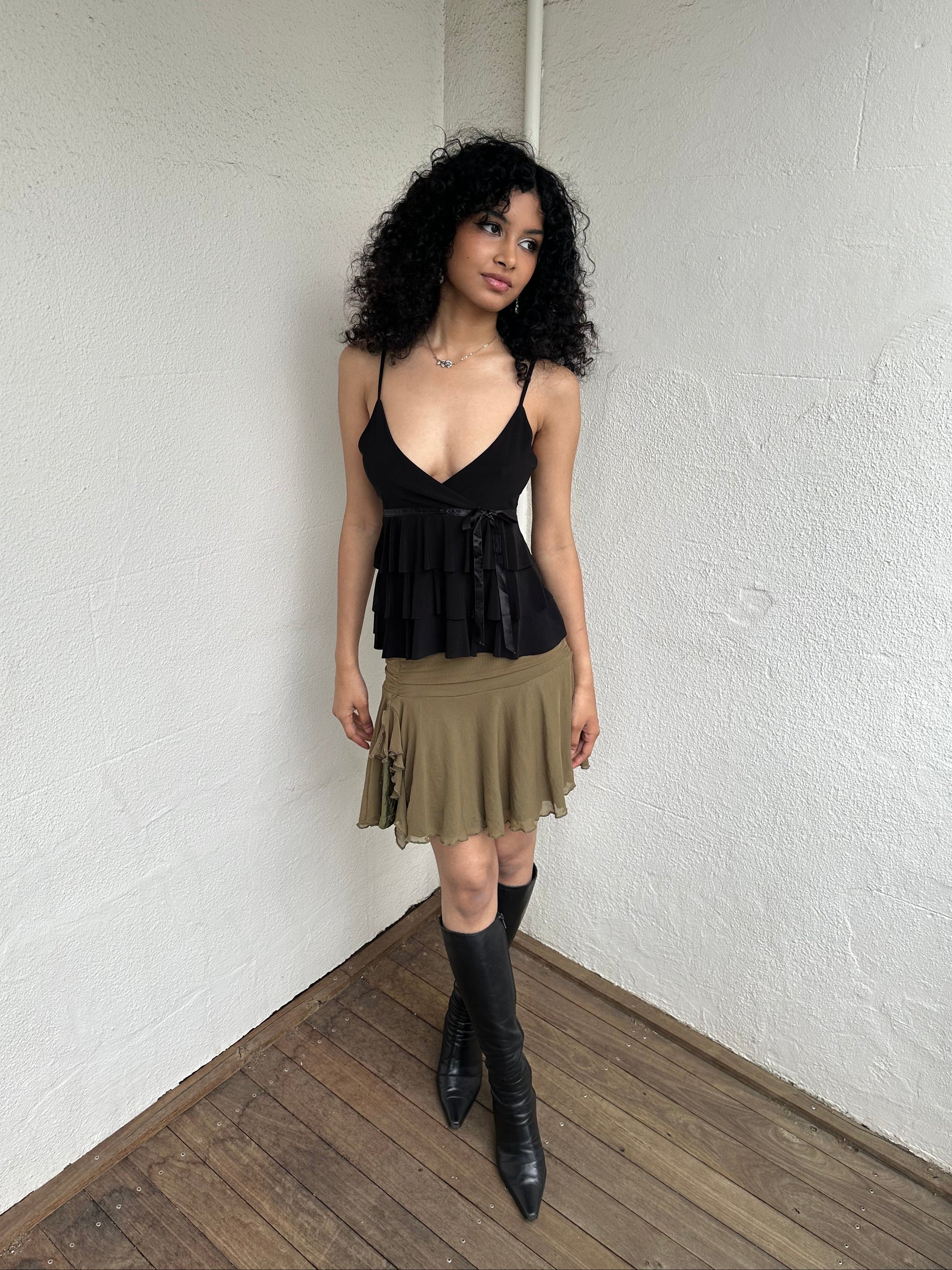 Woman Dressed in Y2K 00s Olive green mesh layered skirt featuring soft mesh layers with a side slit