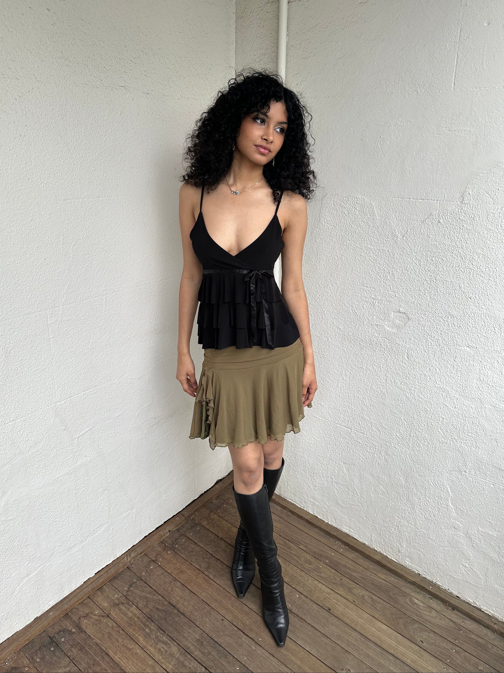 Woman Dressed in Y2K 00s Olive green mesh layered skirt featuring soft mesh layers with a side slit