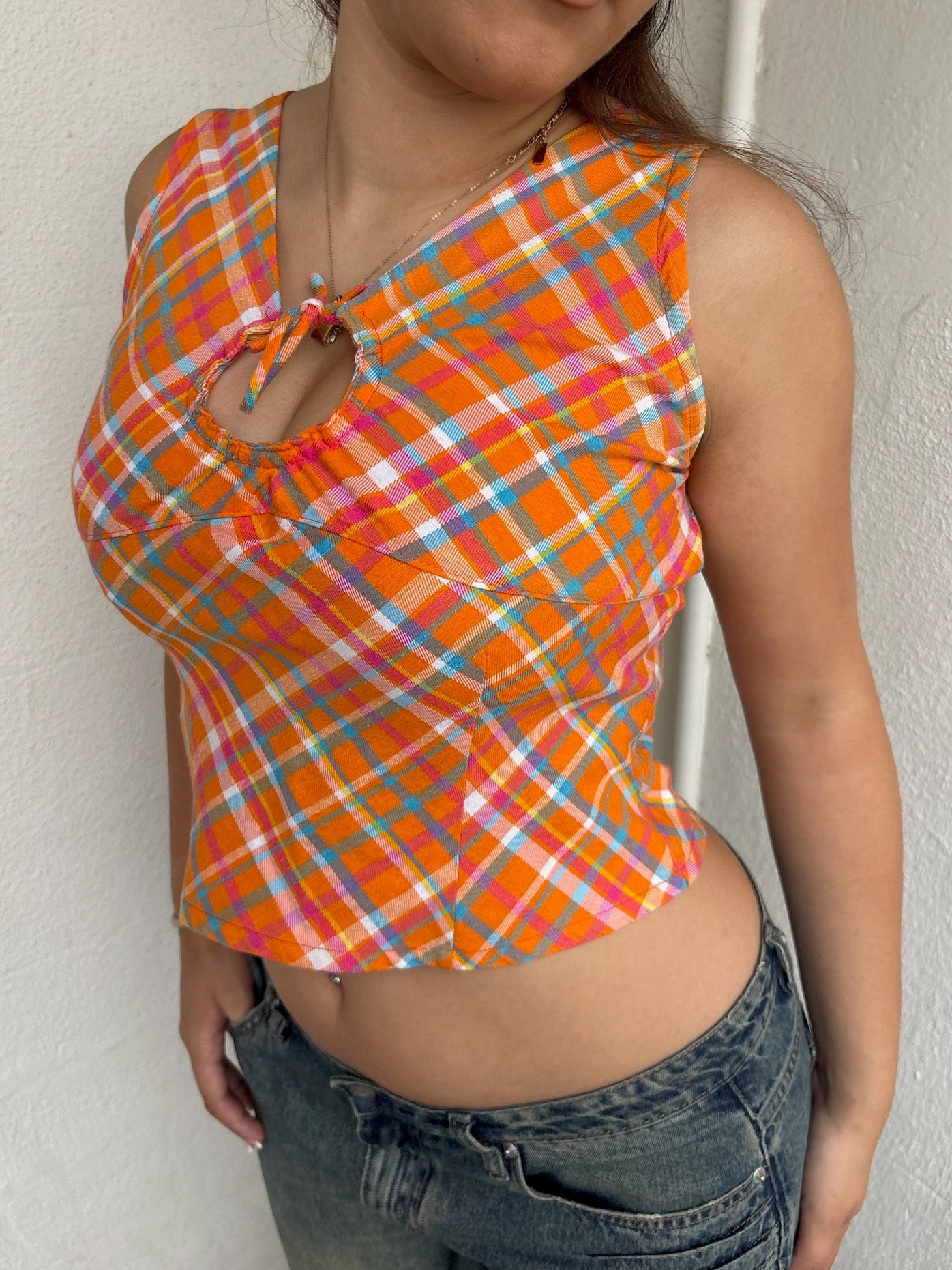 Woman Dressed in Y2K 00s Orange checkered Y2K tank top featuring a bold multi coloured check pattern 