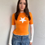 Woman wearing a Y2K 00s Y2K Orange star layered long sleeve top.